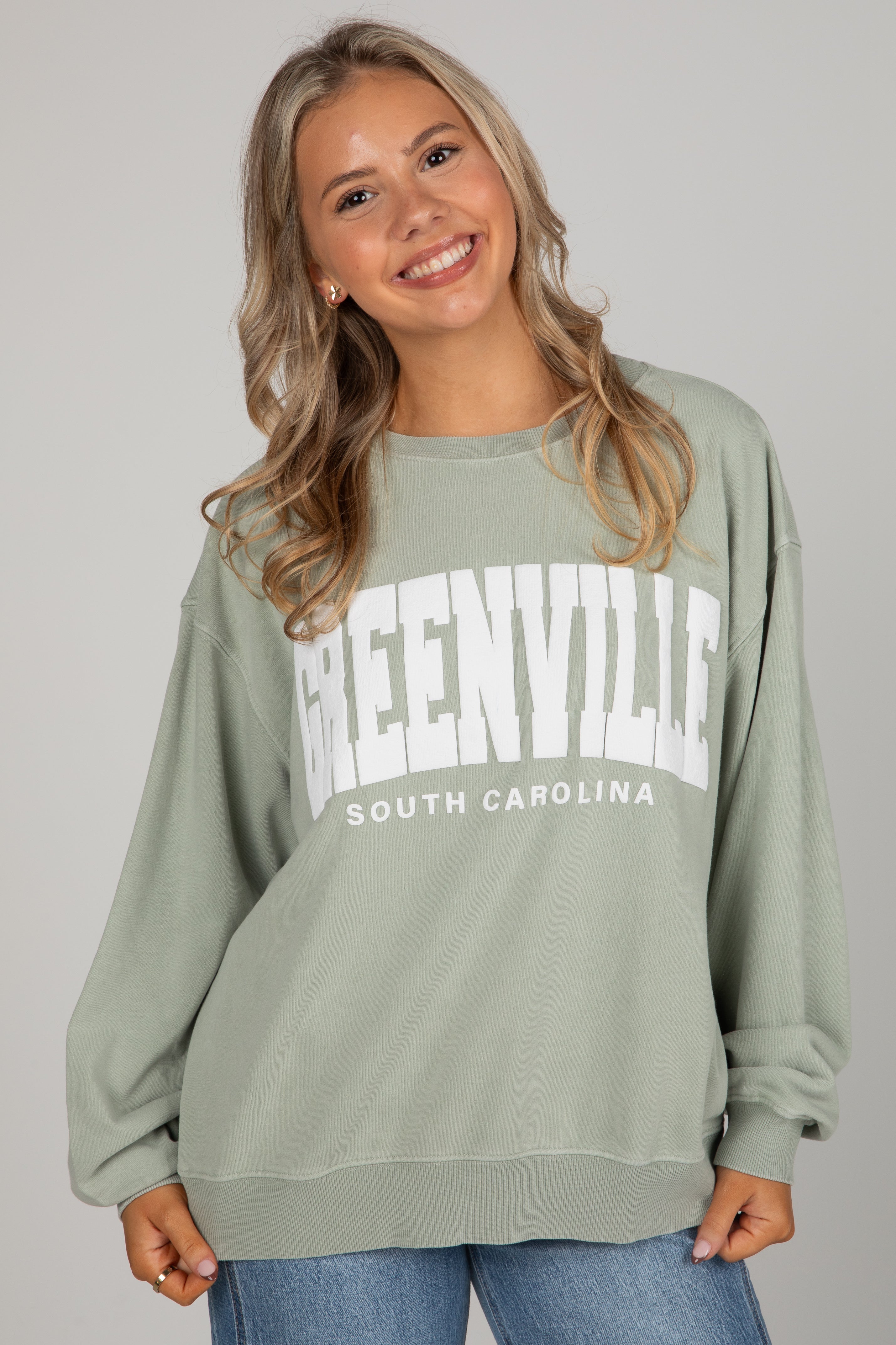 Woman wearing a green sweatshirt with &