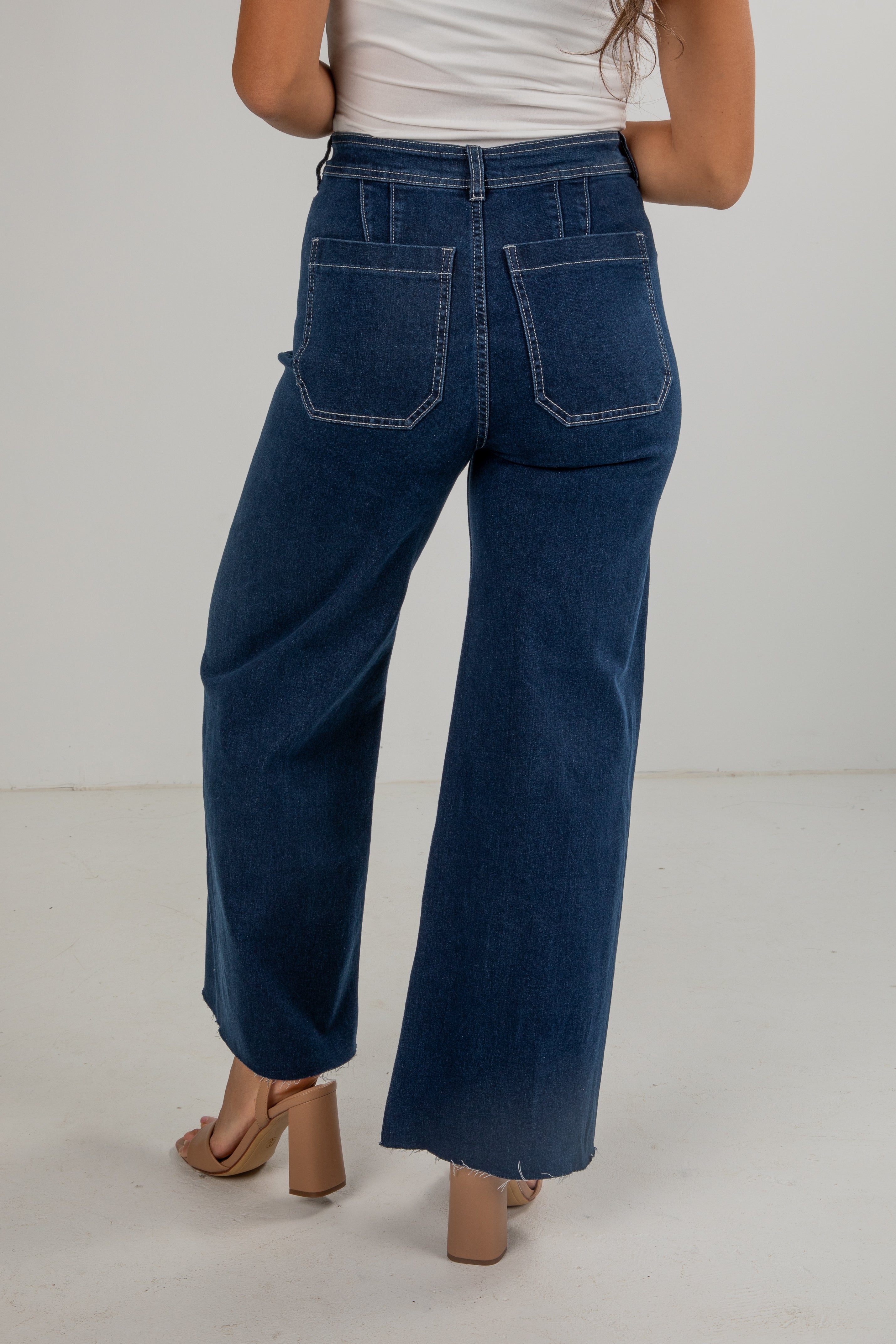 Person wearing blue wide-leg jeans on a plain background