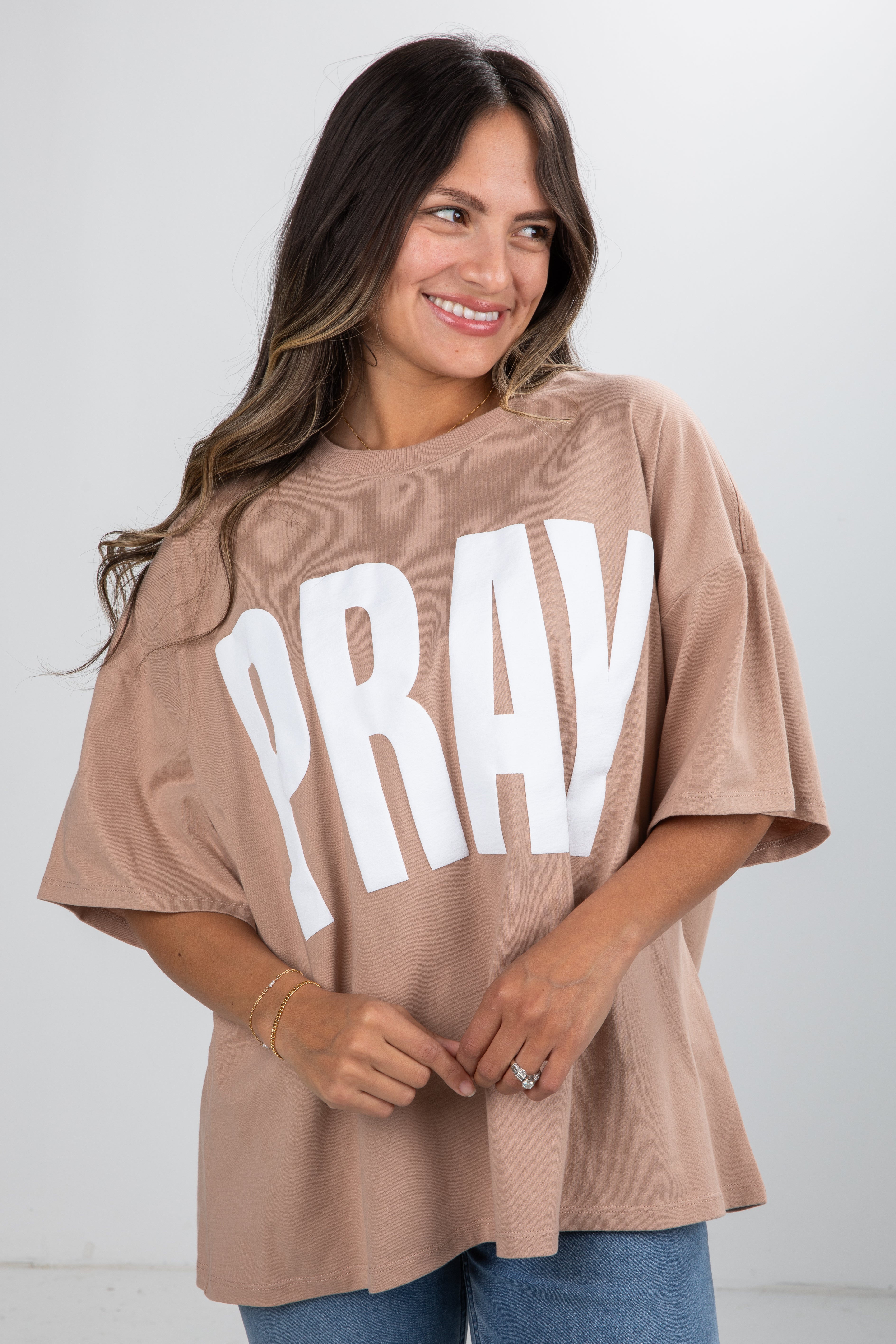 Woman wearing a beige t-shirt with &