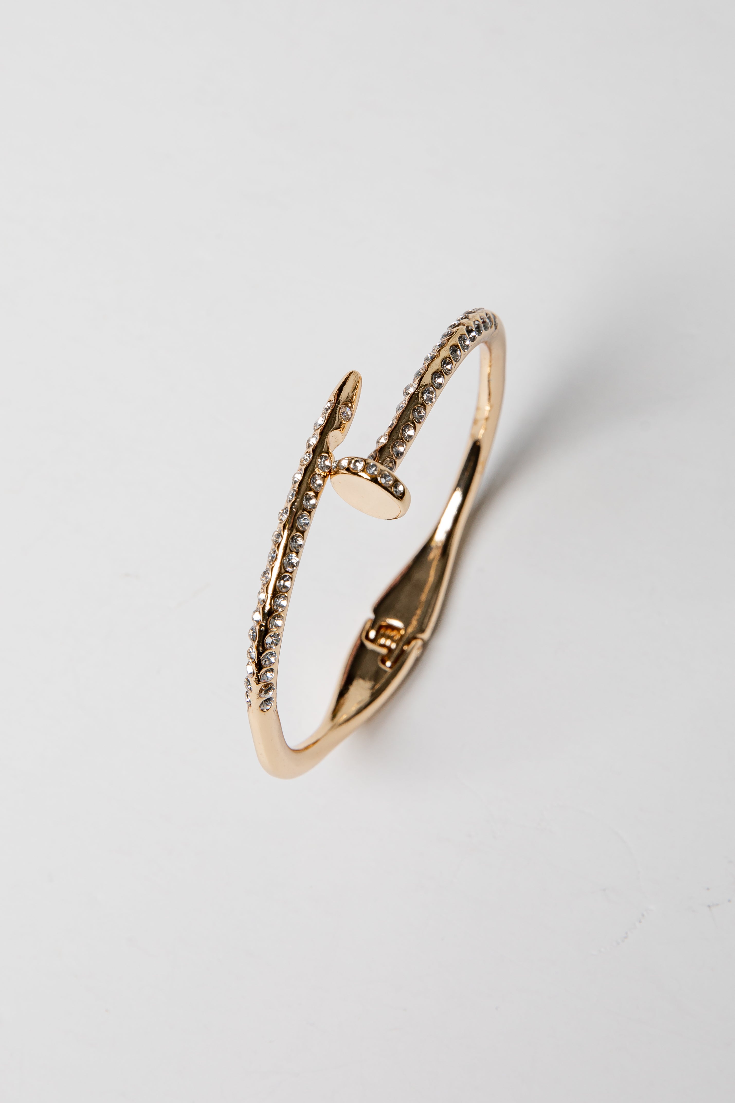 Gold bracelet on a light gray background