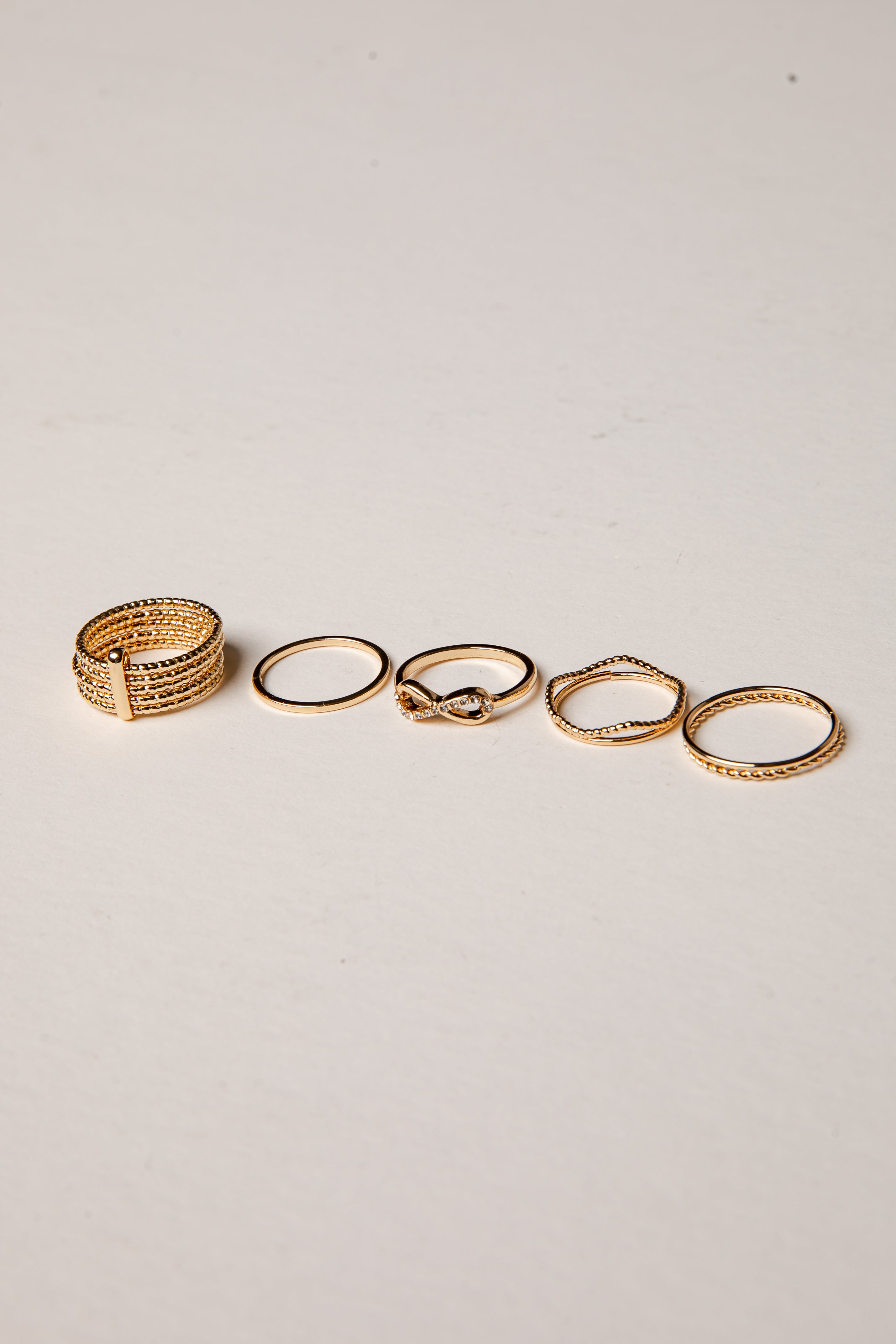 Set of gold rings on a light gray background
