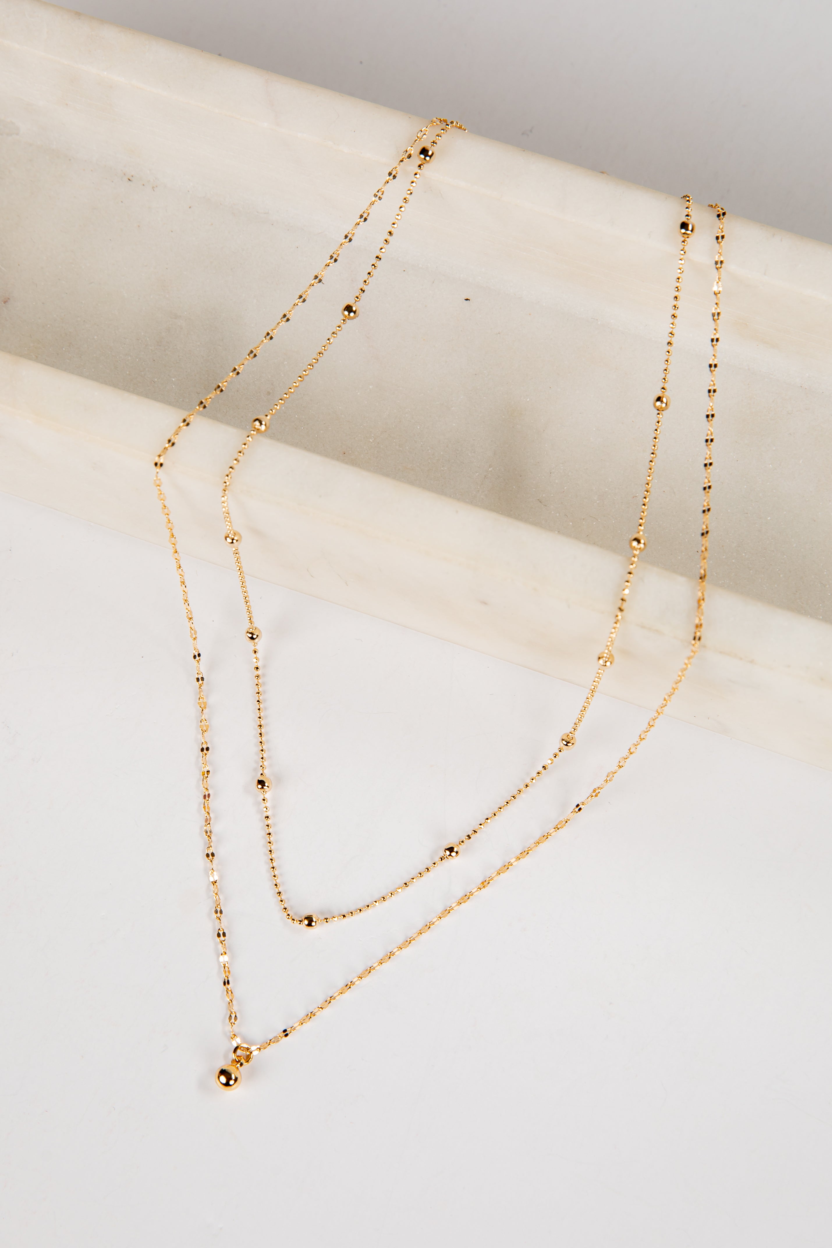 Gold necklace on a white surface