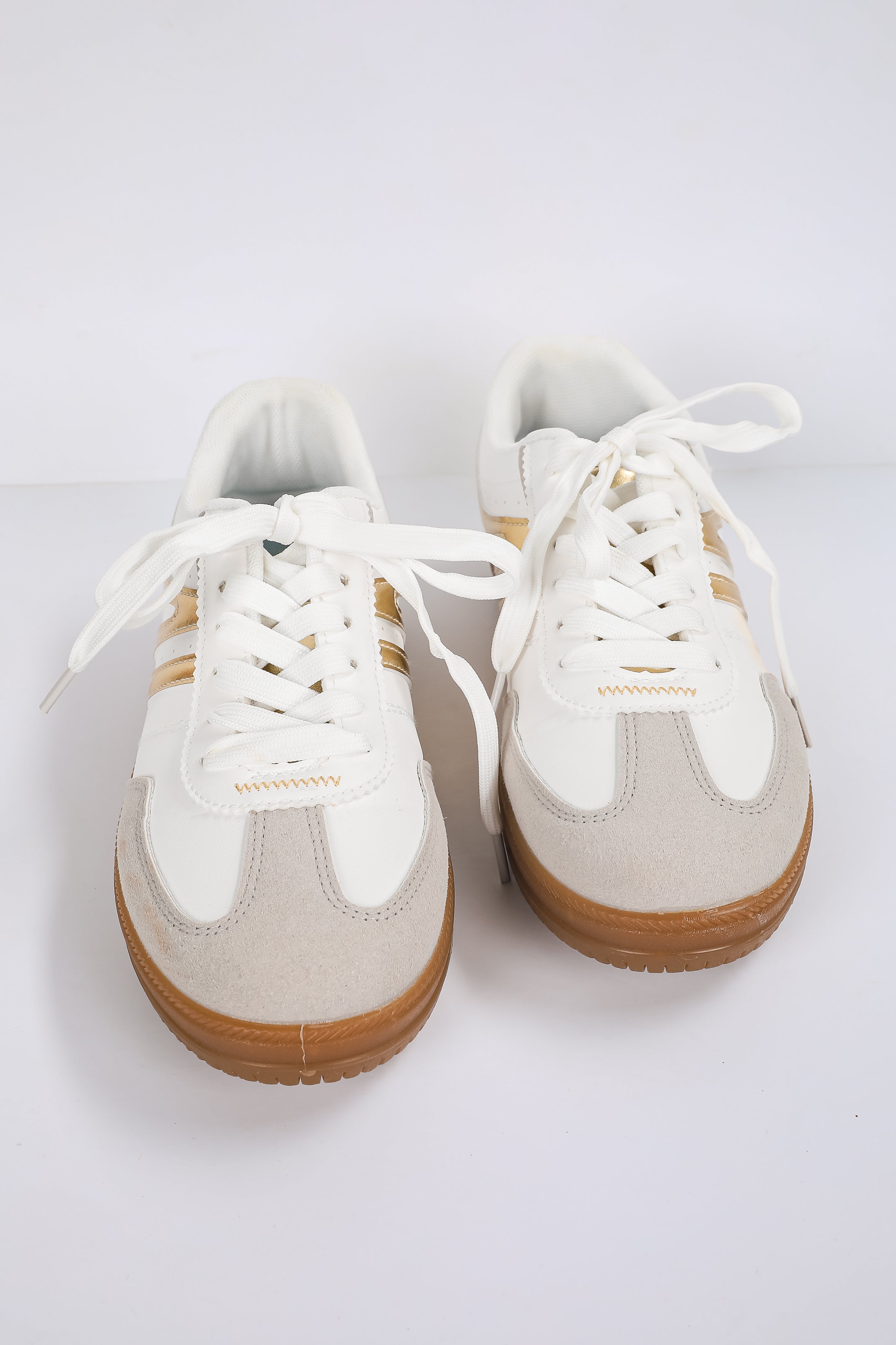 White sneakers with brown soles on a white background