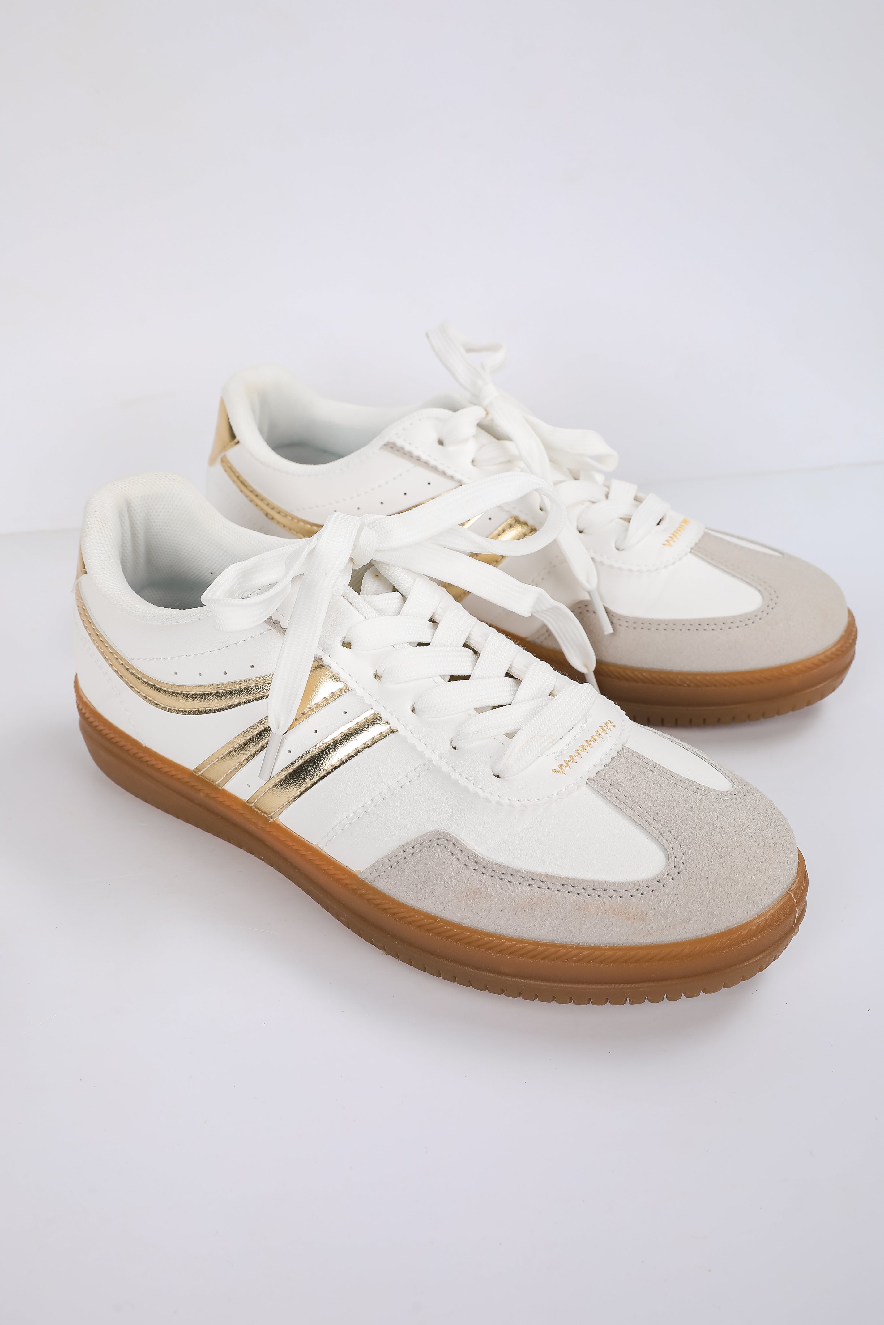White sneakers with brown soles on a white background