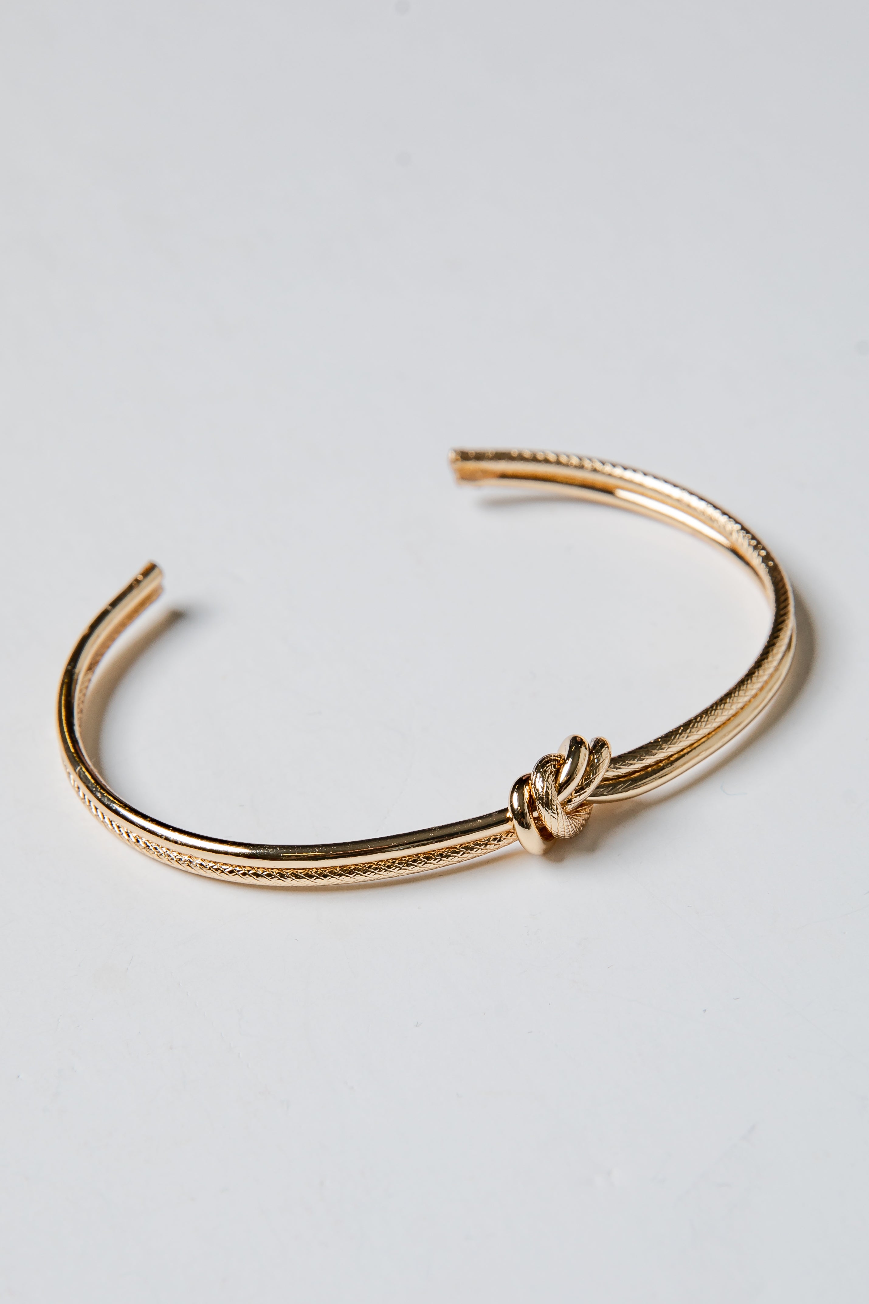 Gold bracelet on a light gray background
