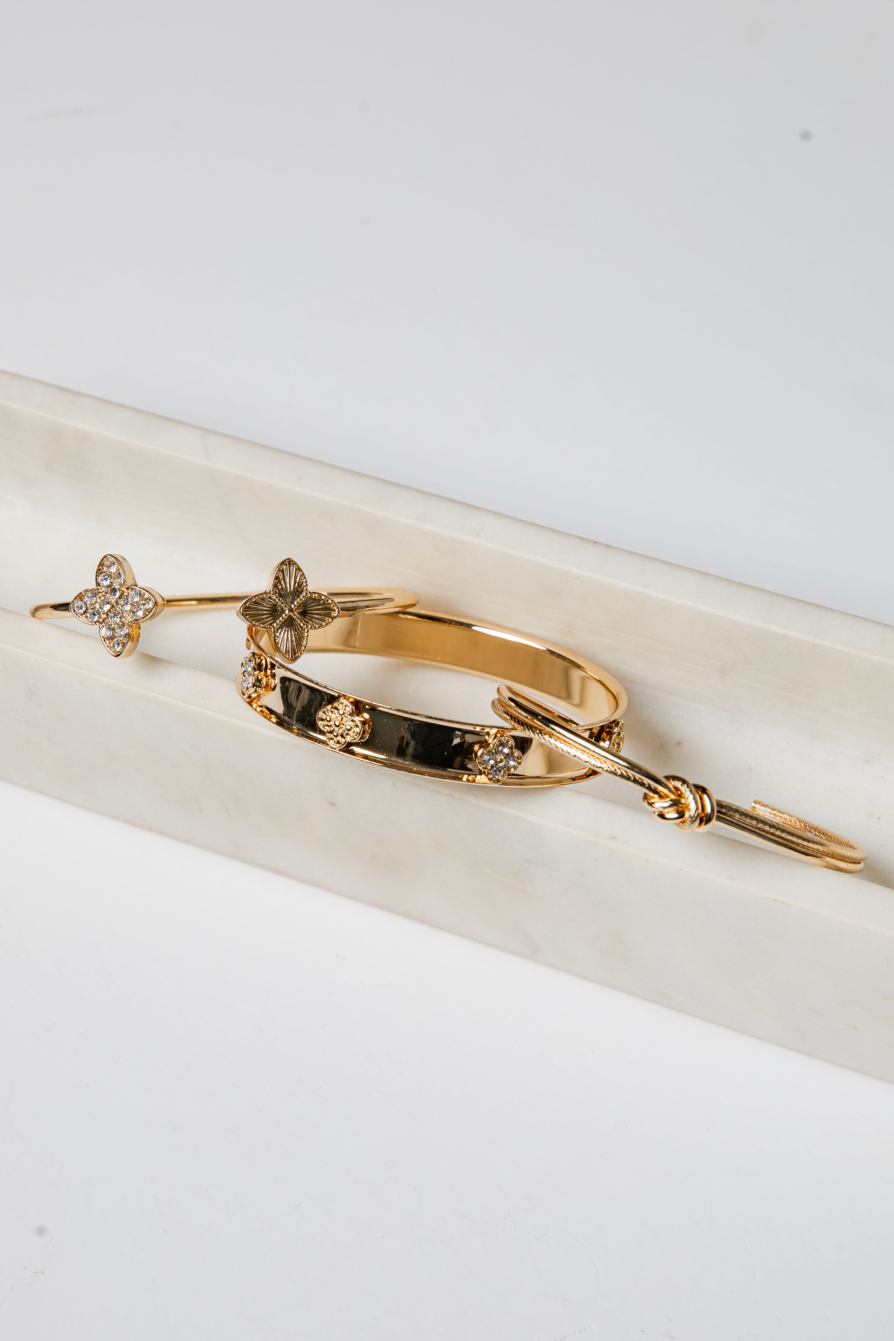 Gold bracelet with embedded stones on a white surface