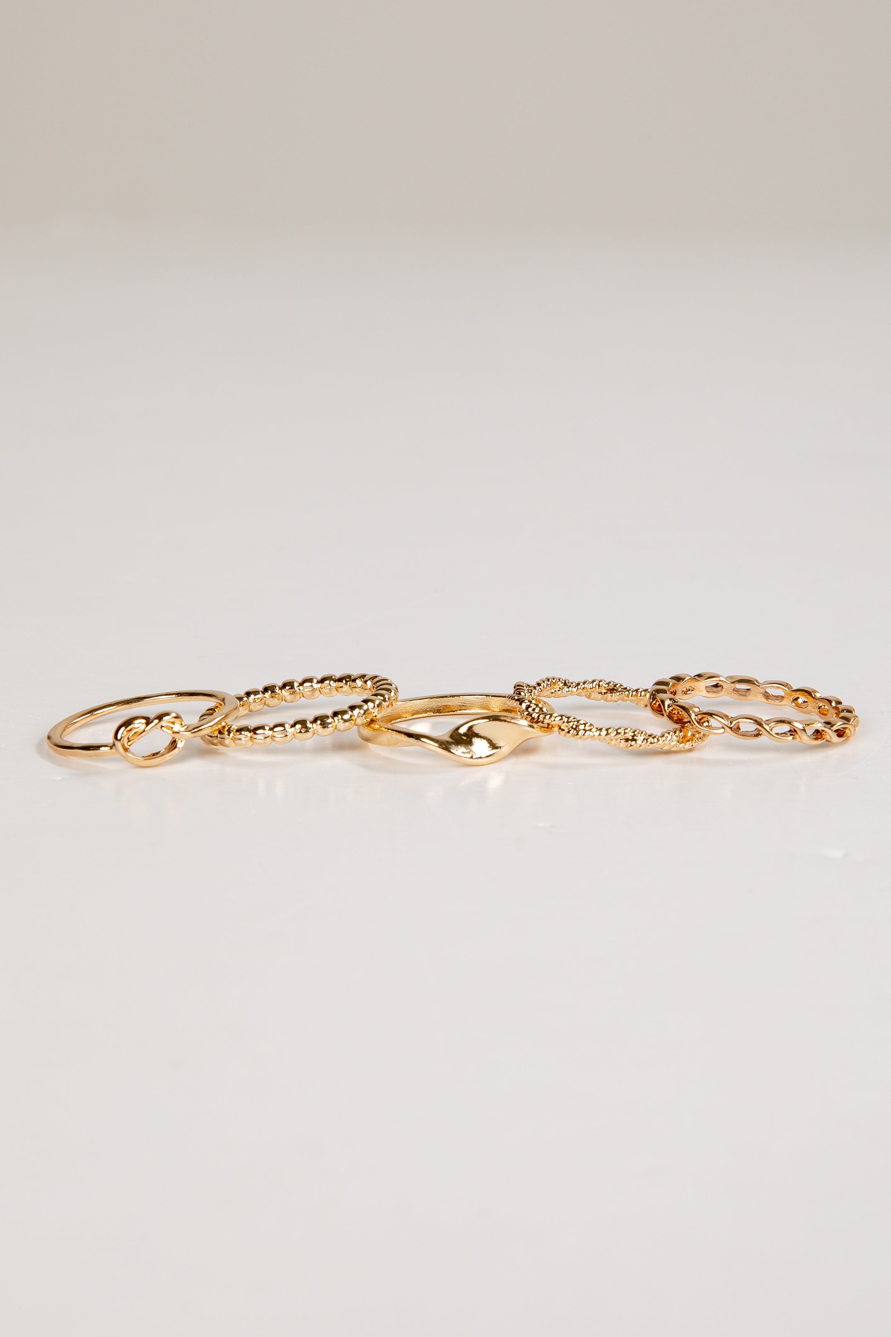 Set of gold rings on a light gray background