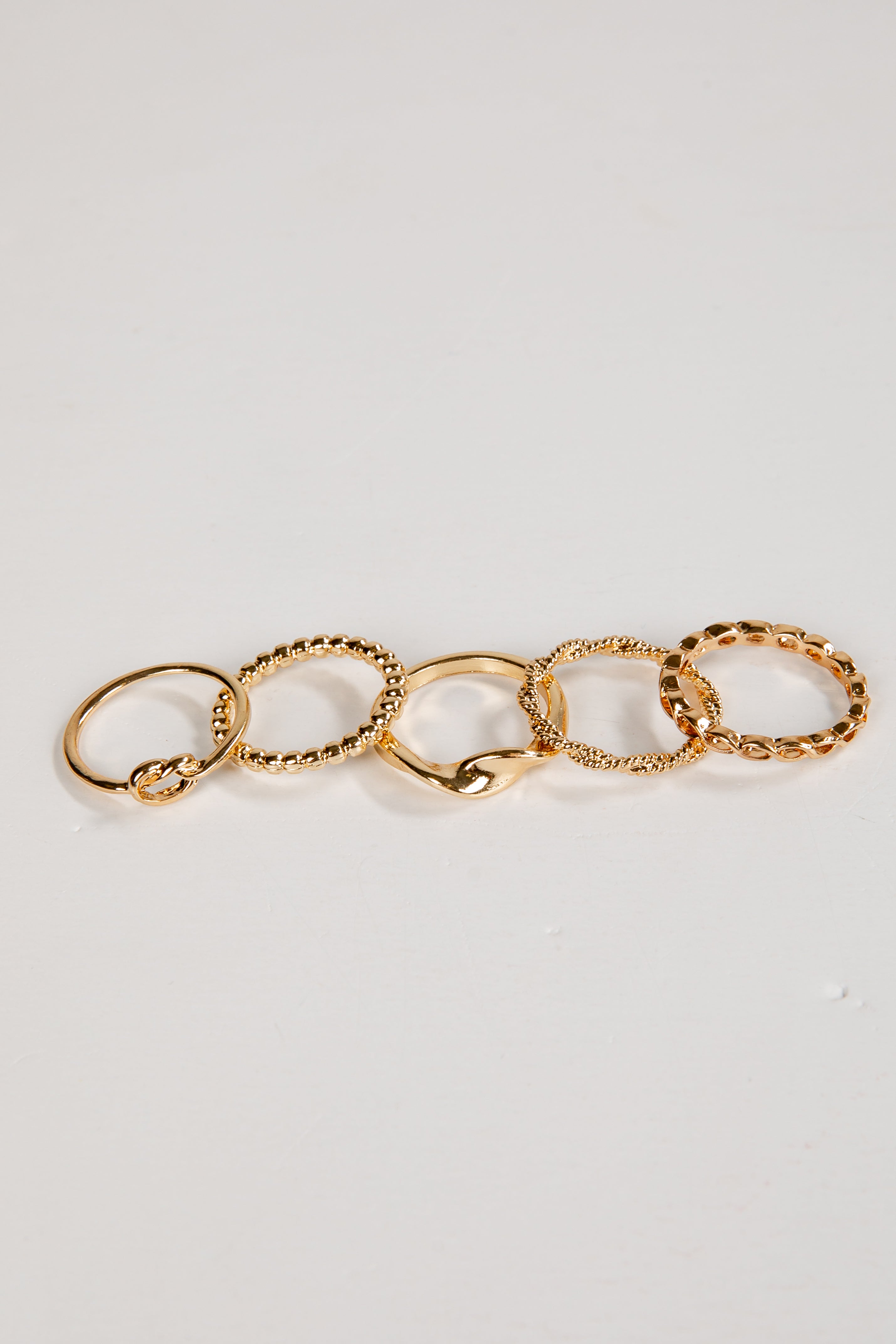 Set of gold rings on a light gray background