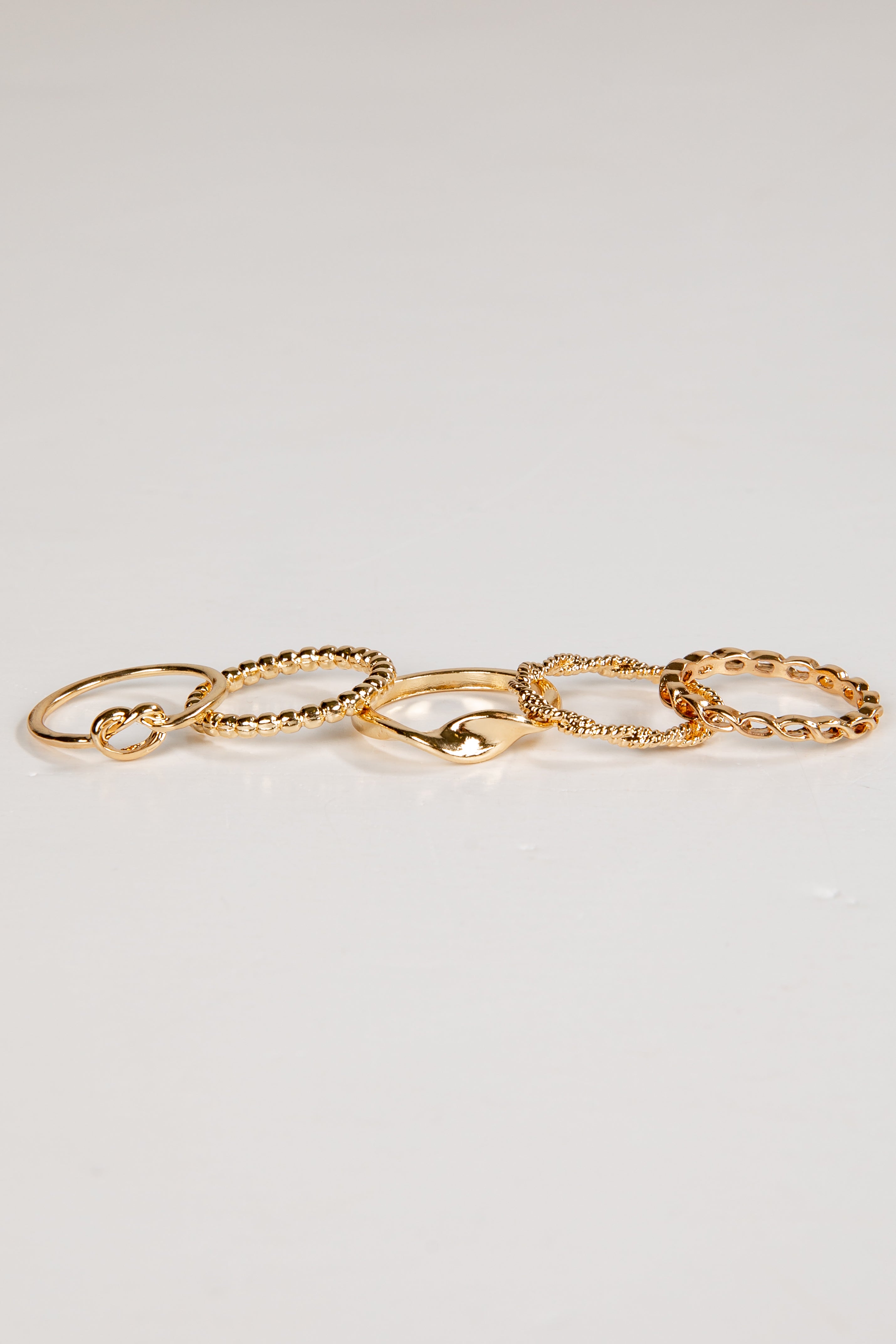 Set of gold chain rings on a light gray background