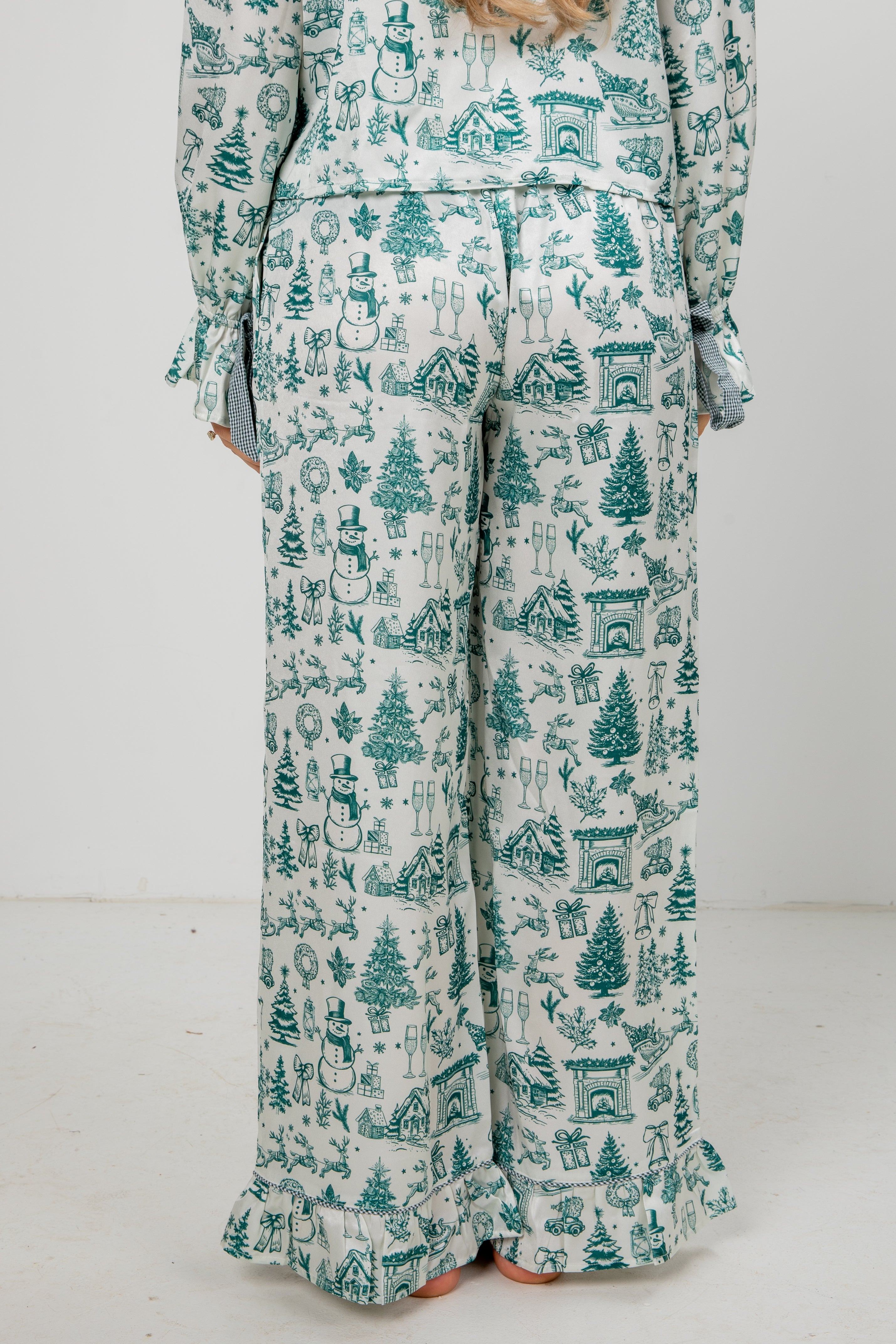 Person wearing a festive pajama set with green and white pattern on a white background