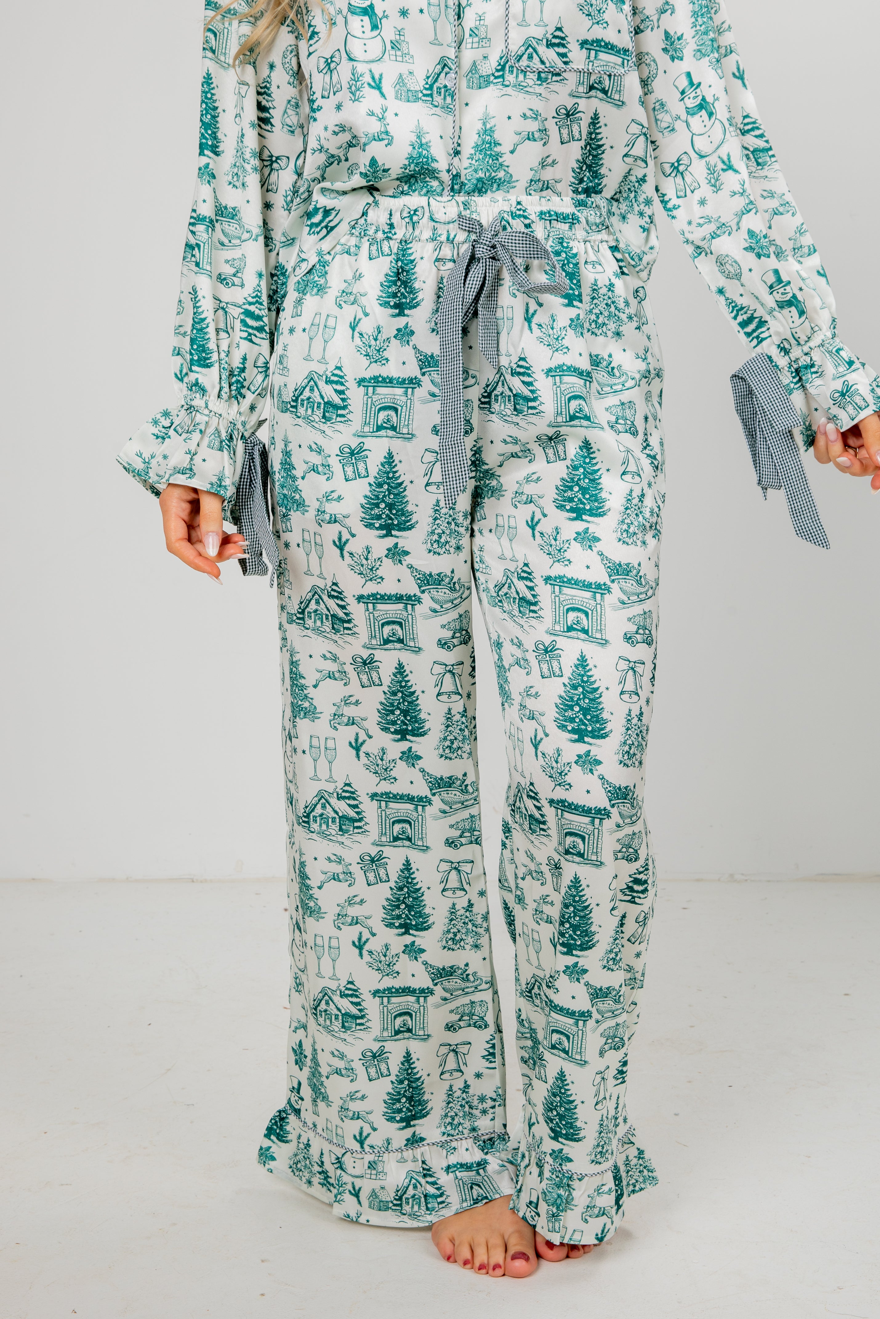 Person wearing a teal and white patterned pajama set on a plain background