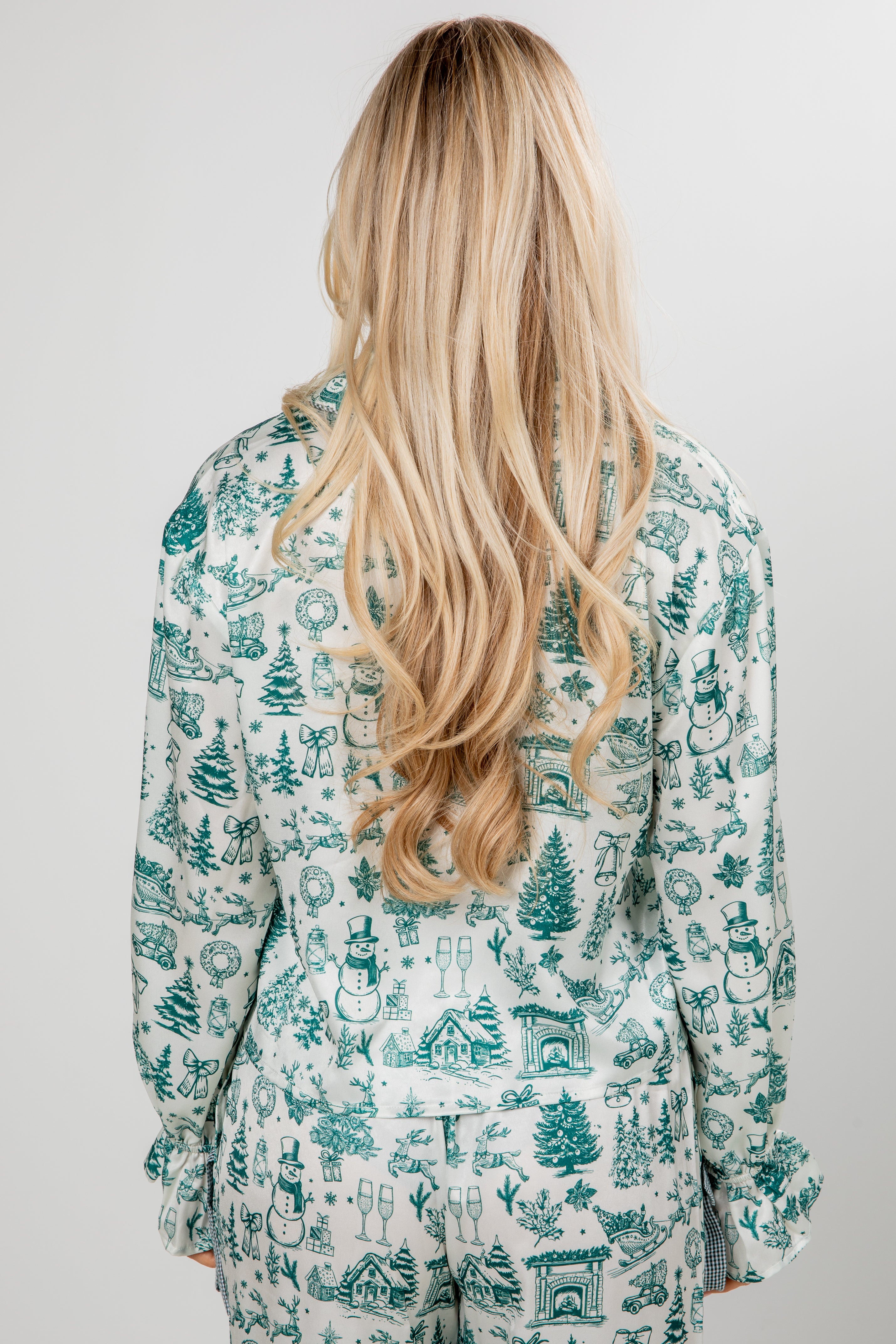 Person wearing a patterned shirt with long blonde hair, on a plain background