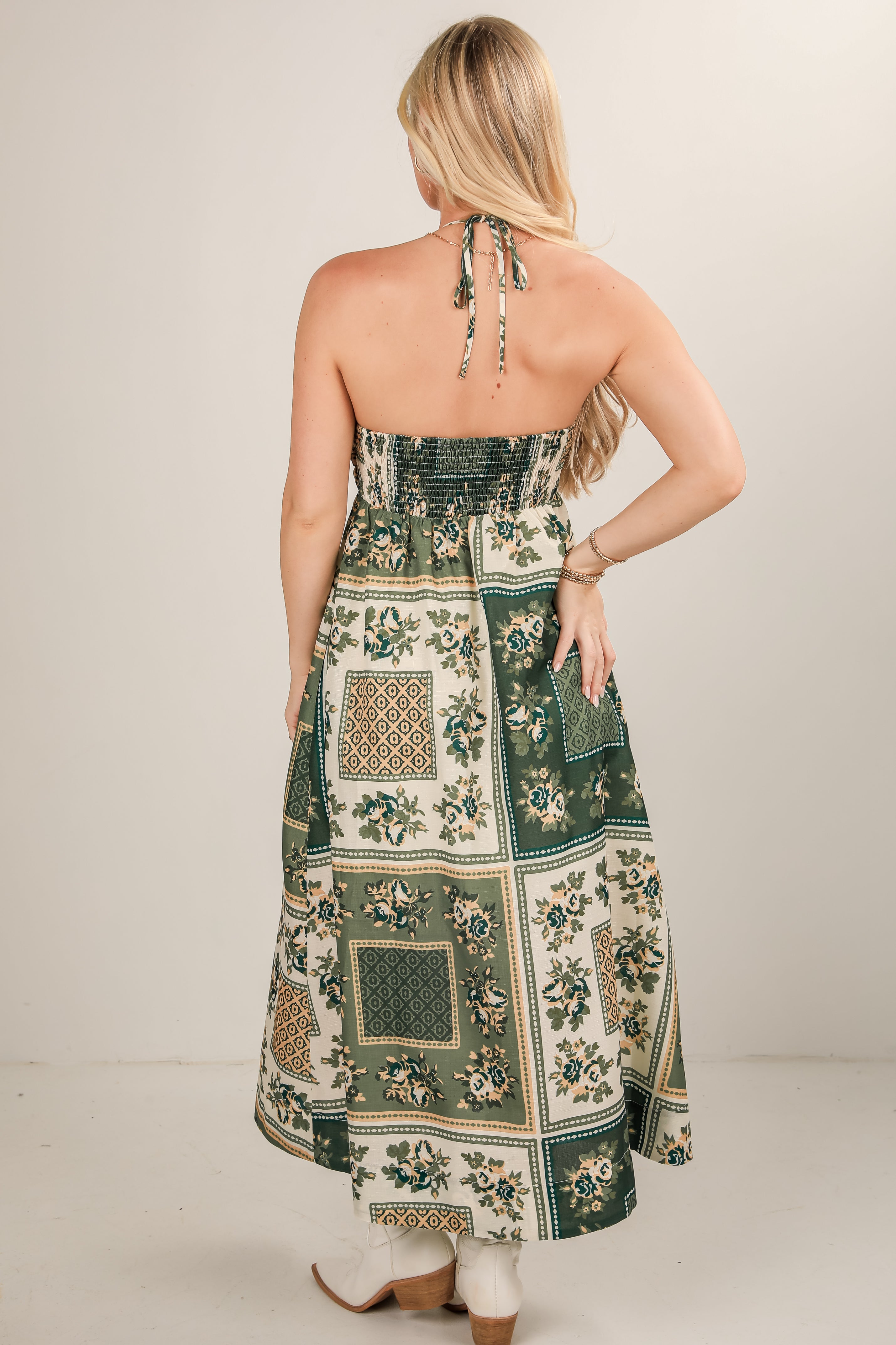 Woman wearing a floral and geometric patterned dress against a plain background