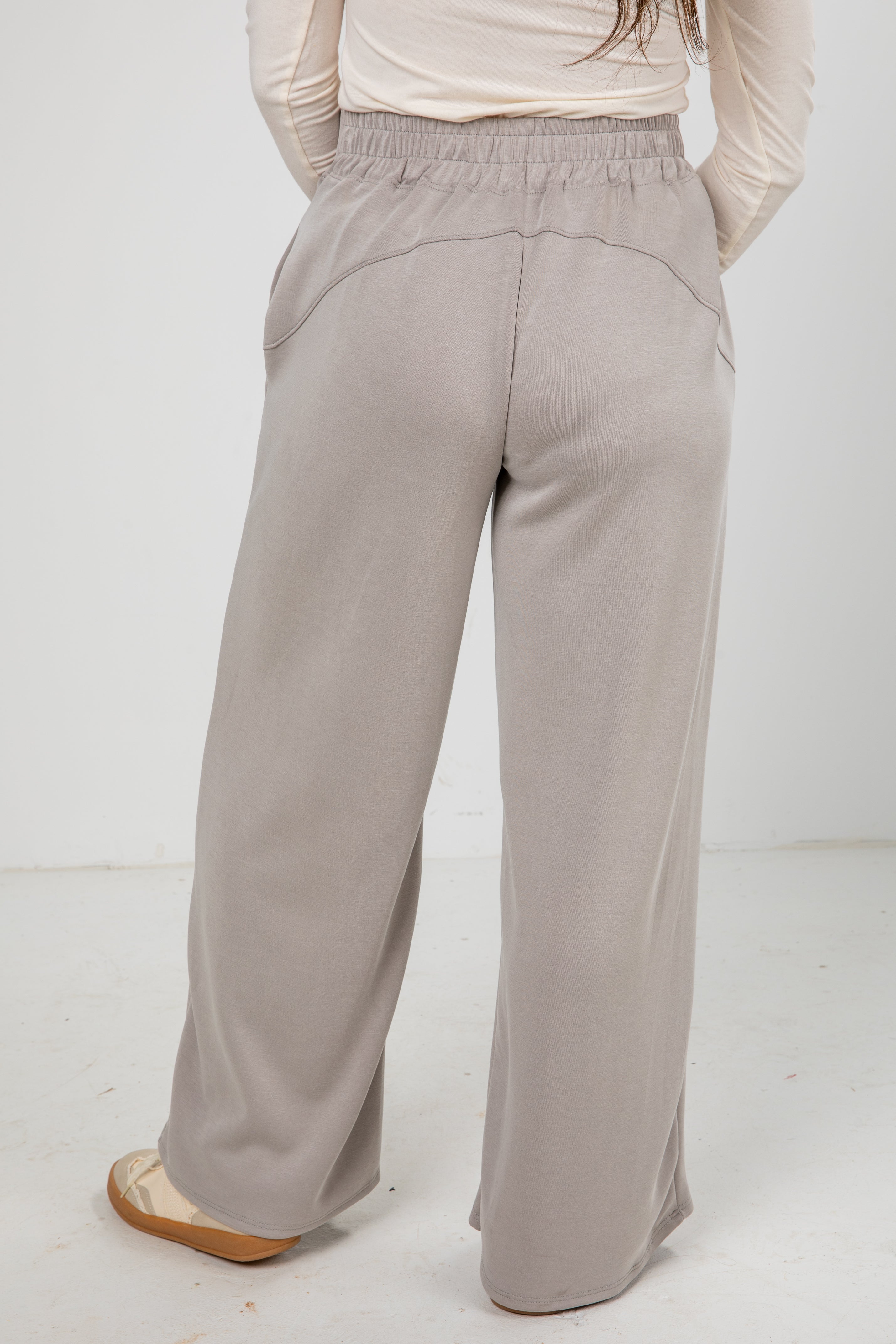 Light gray wide-leg pants worn by a person on a white background