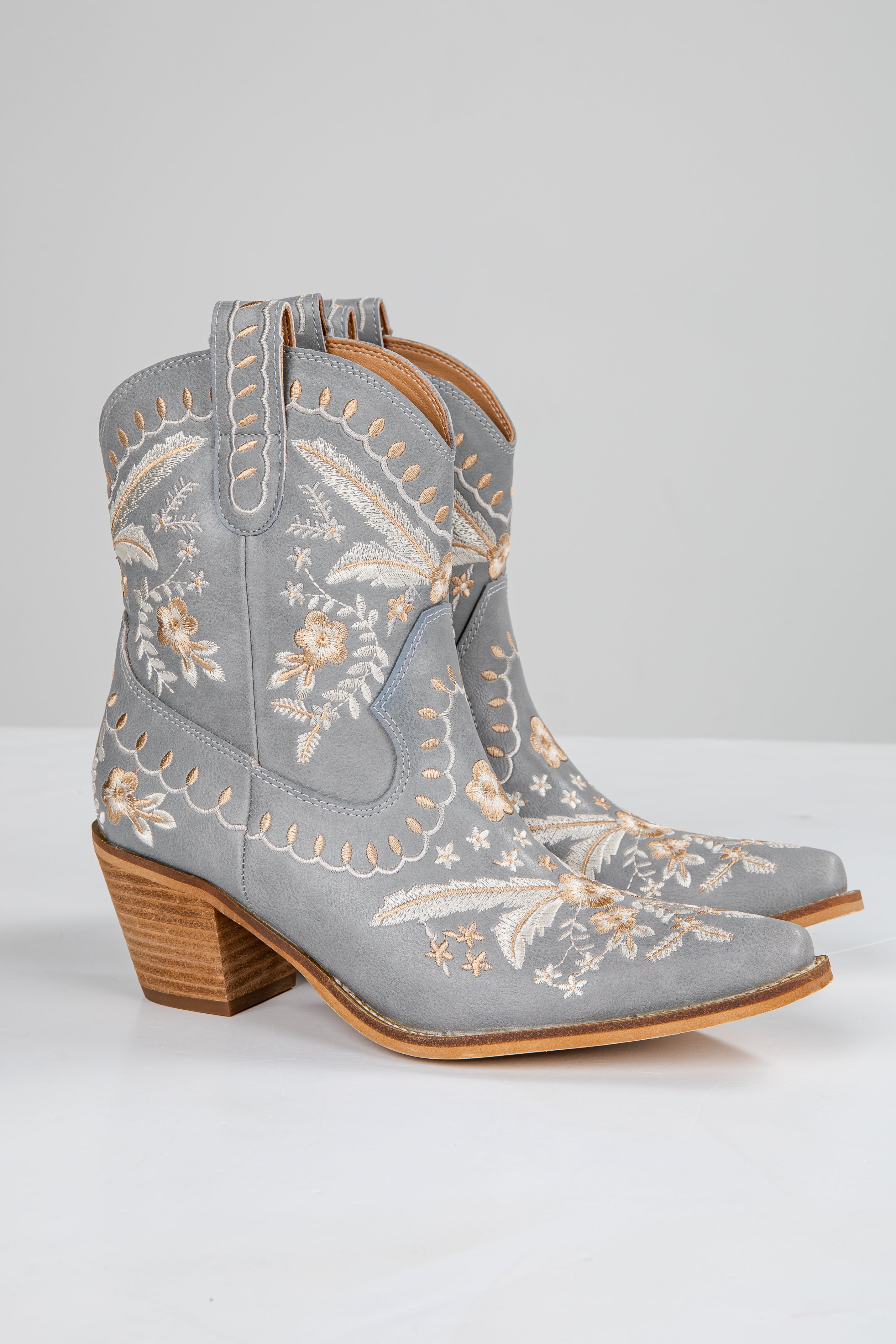 Gray embroidered cowboy boots with wooden heel on a white background