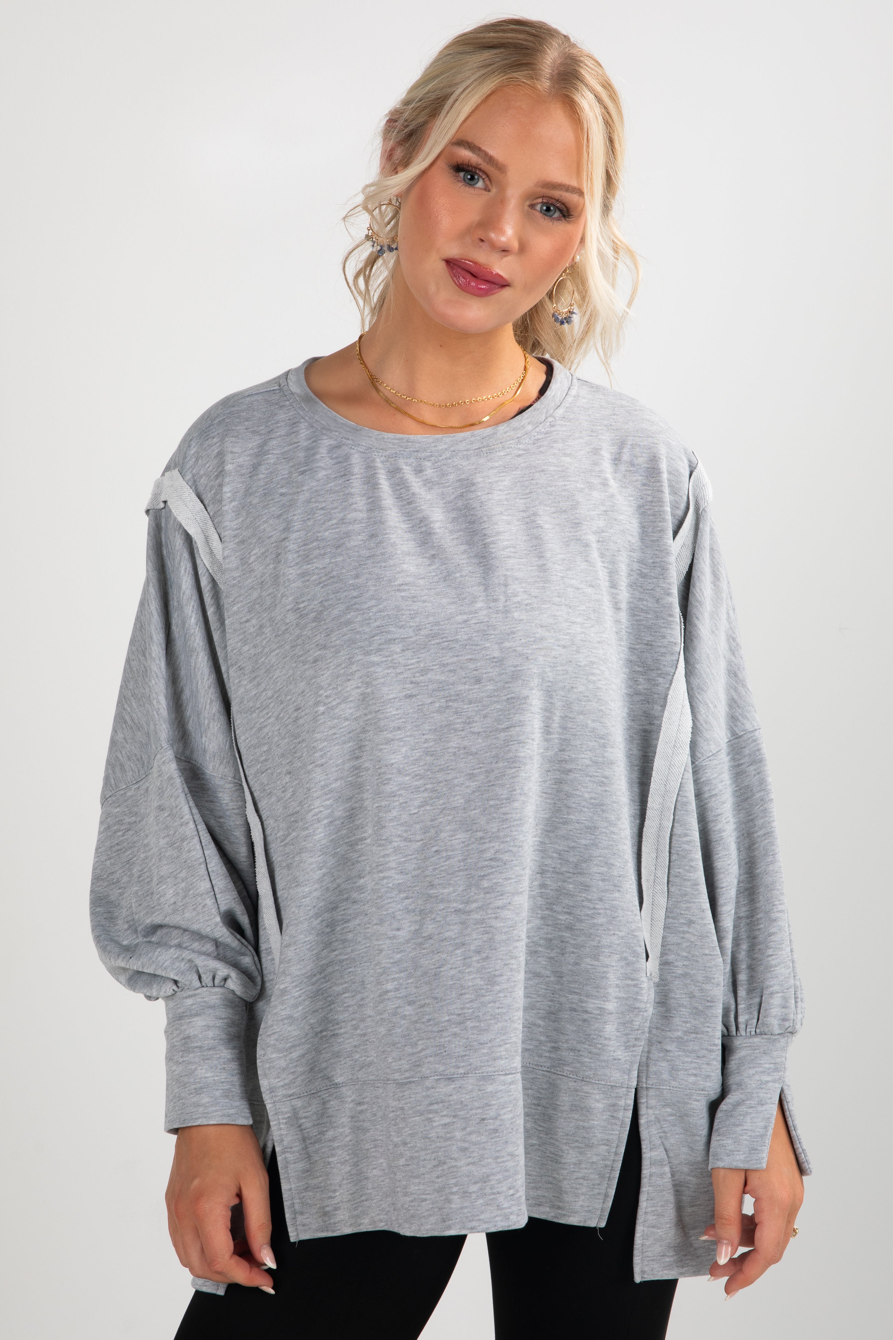 Woman wearing a gray oversized sweater on a white background