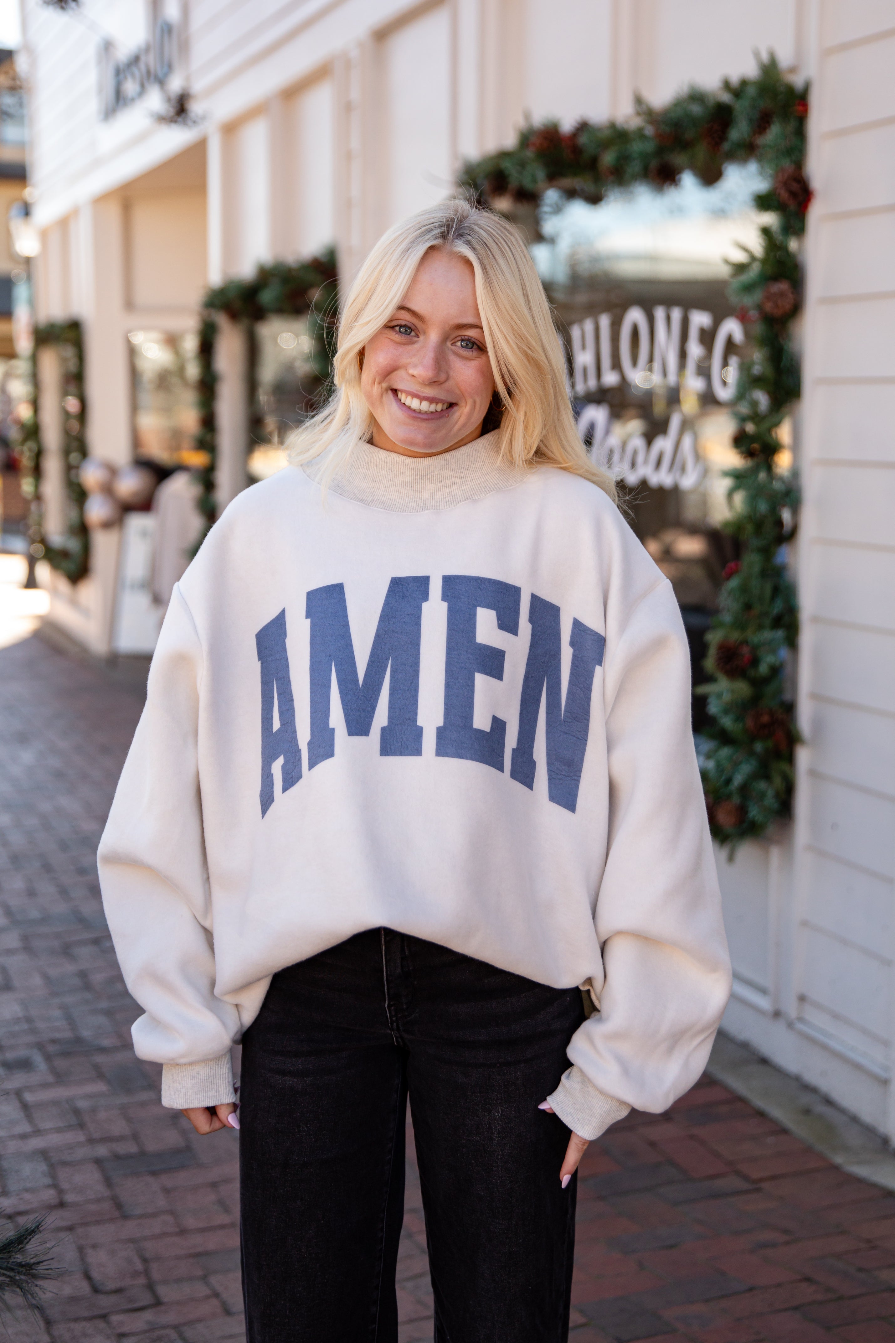 Woman wearing a white sweater with &