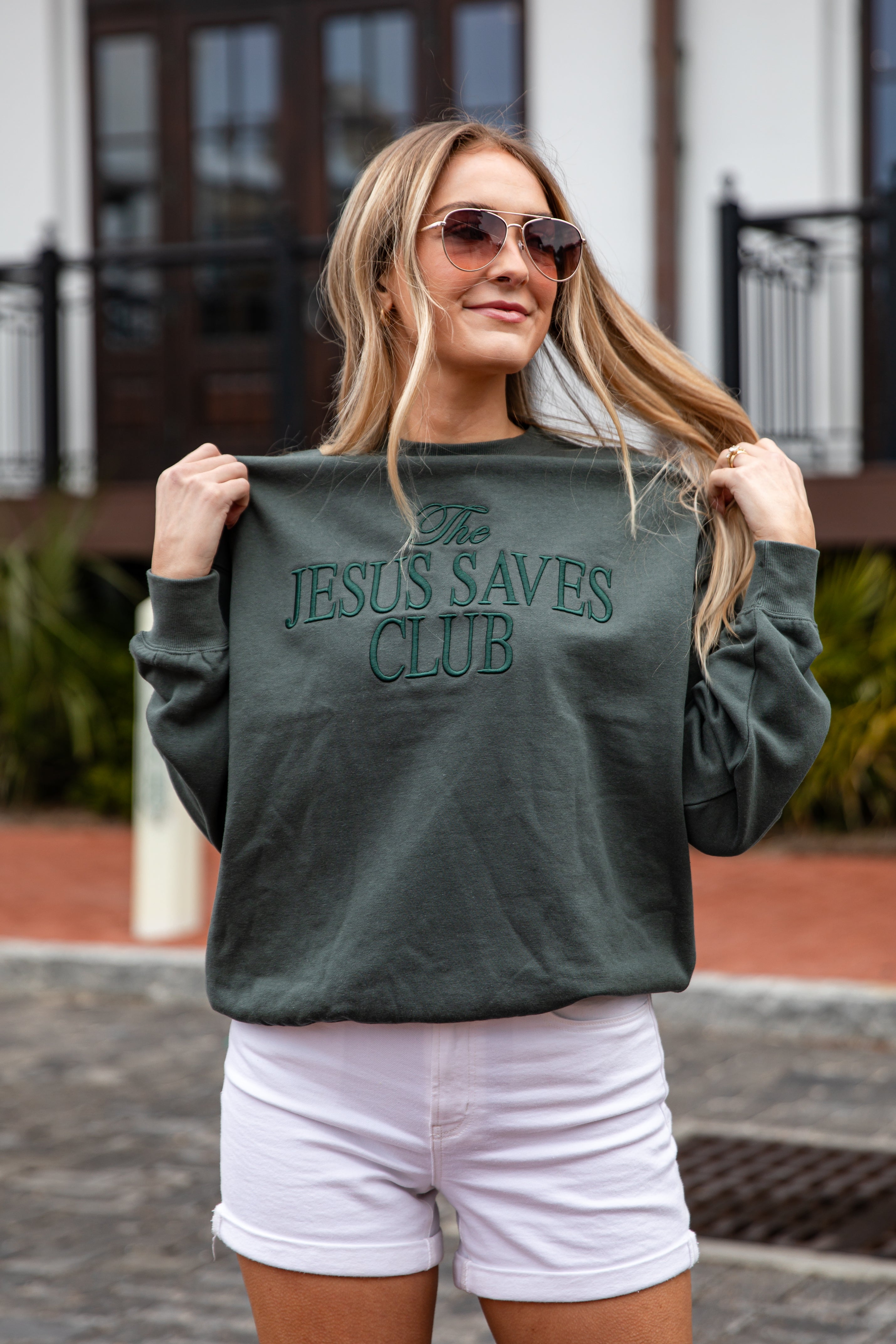 Woman wearing a green sweatshirt with &