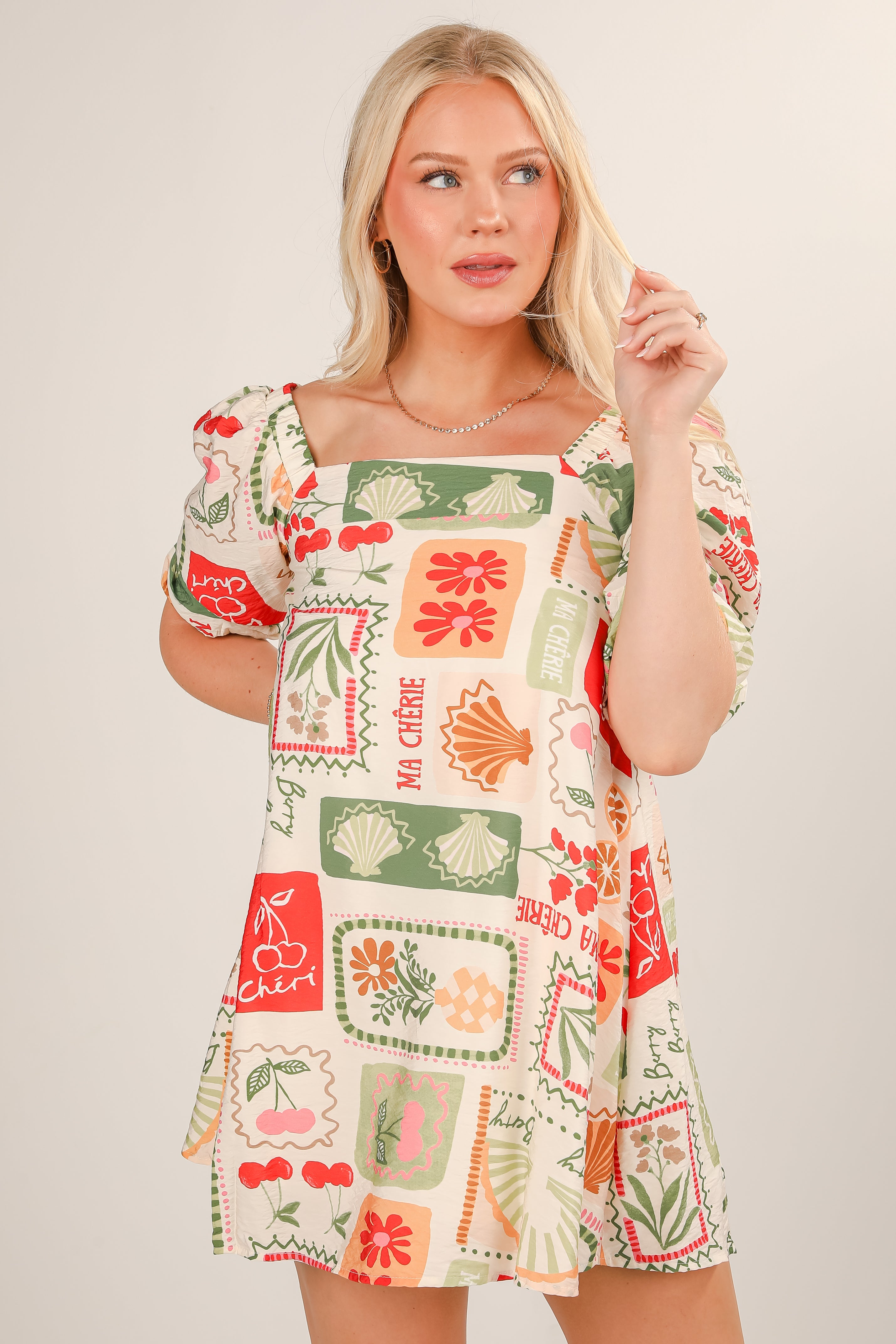Woman wearing a colorful patterned dress on a plain background