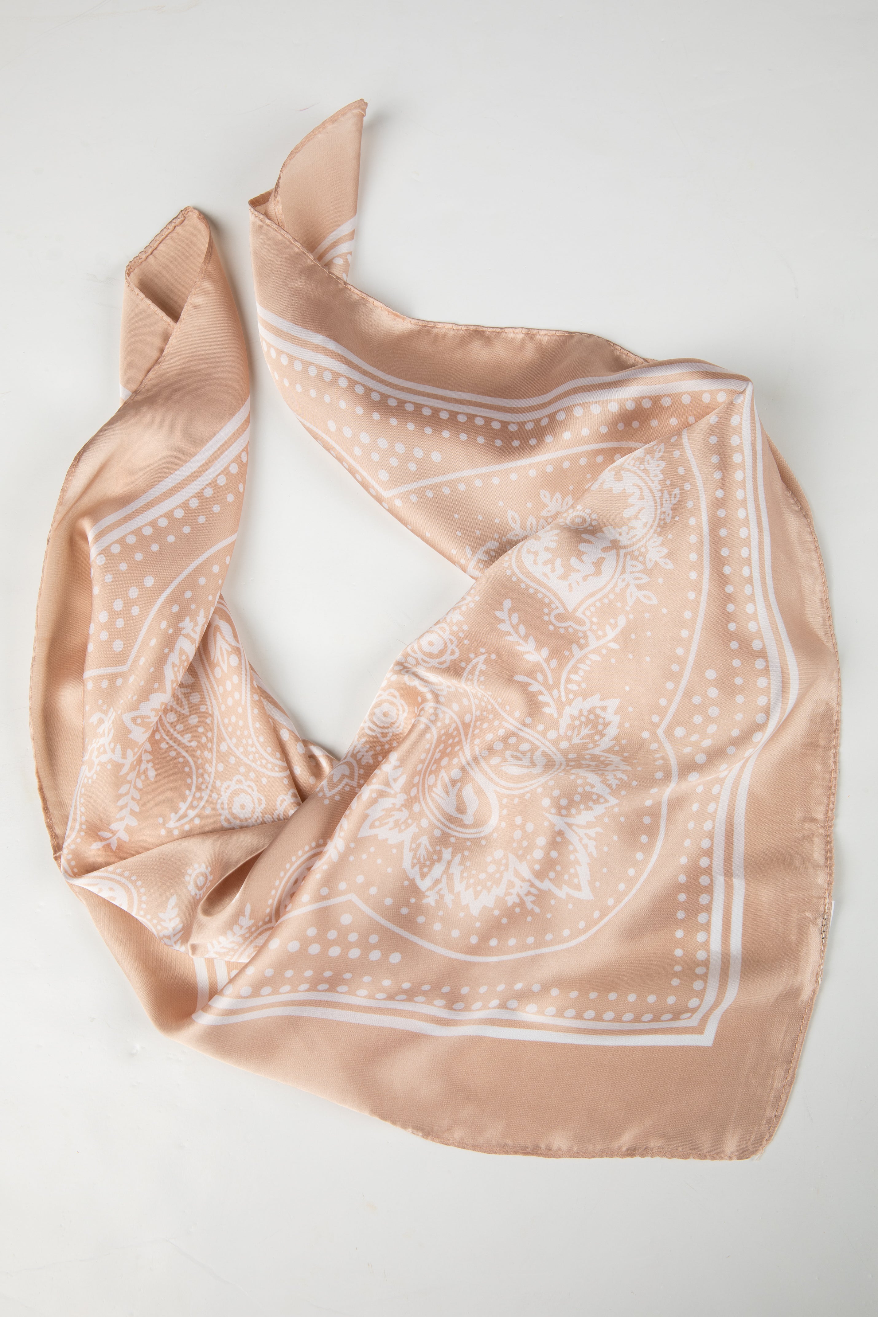 Beige scarf with white pattern on a light gray background