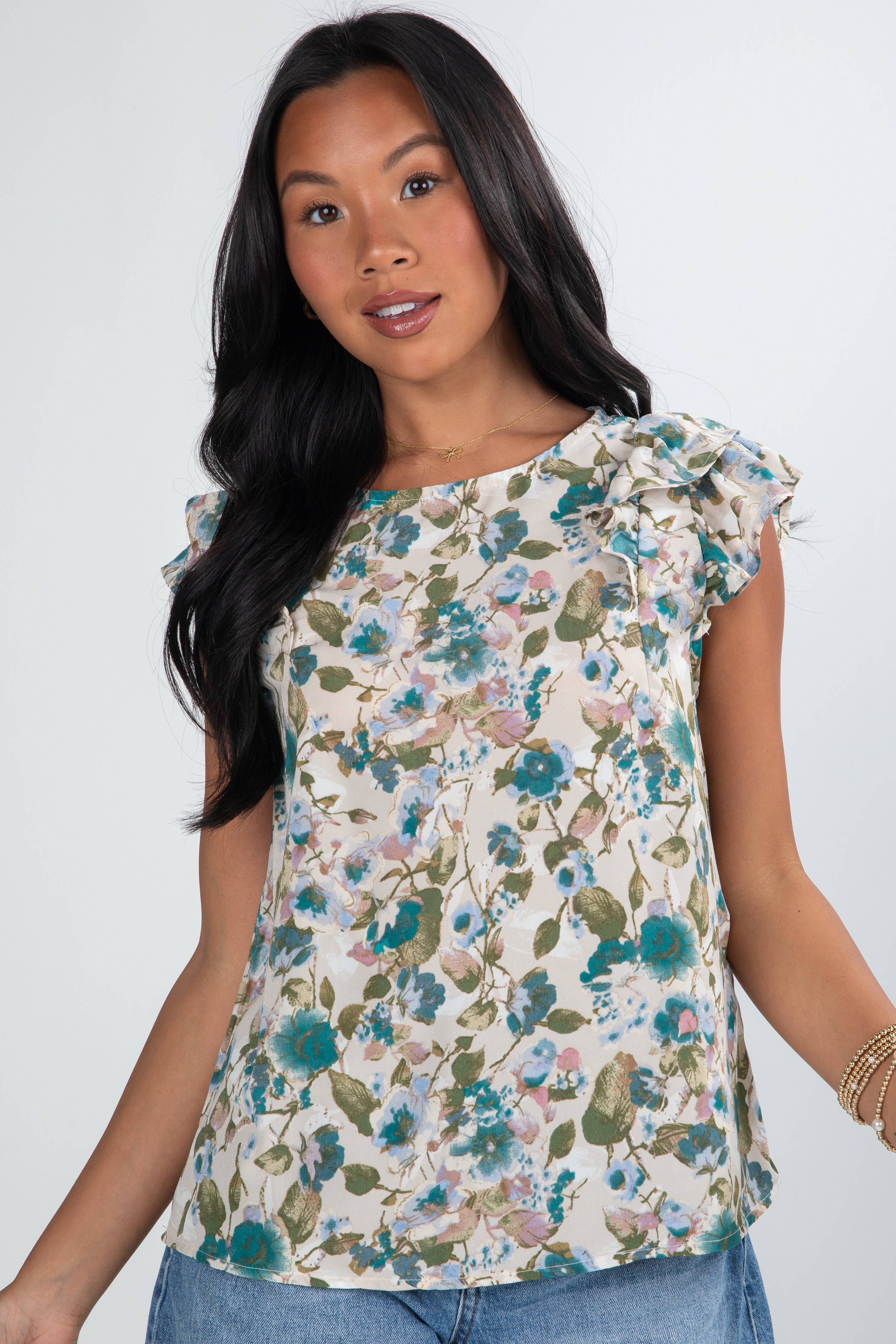 Woman wearing a floral top against a plain background