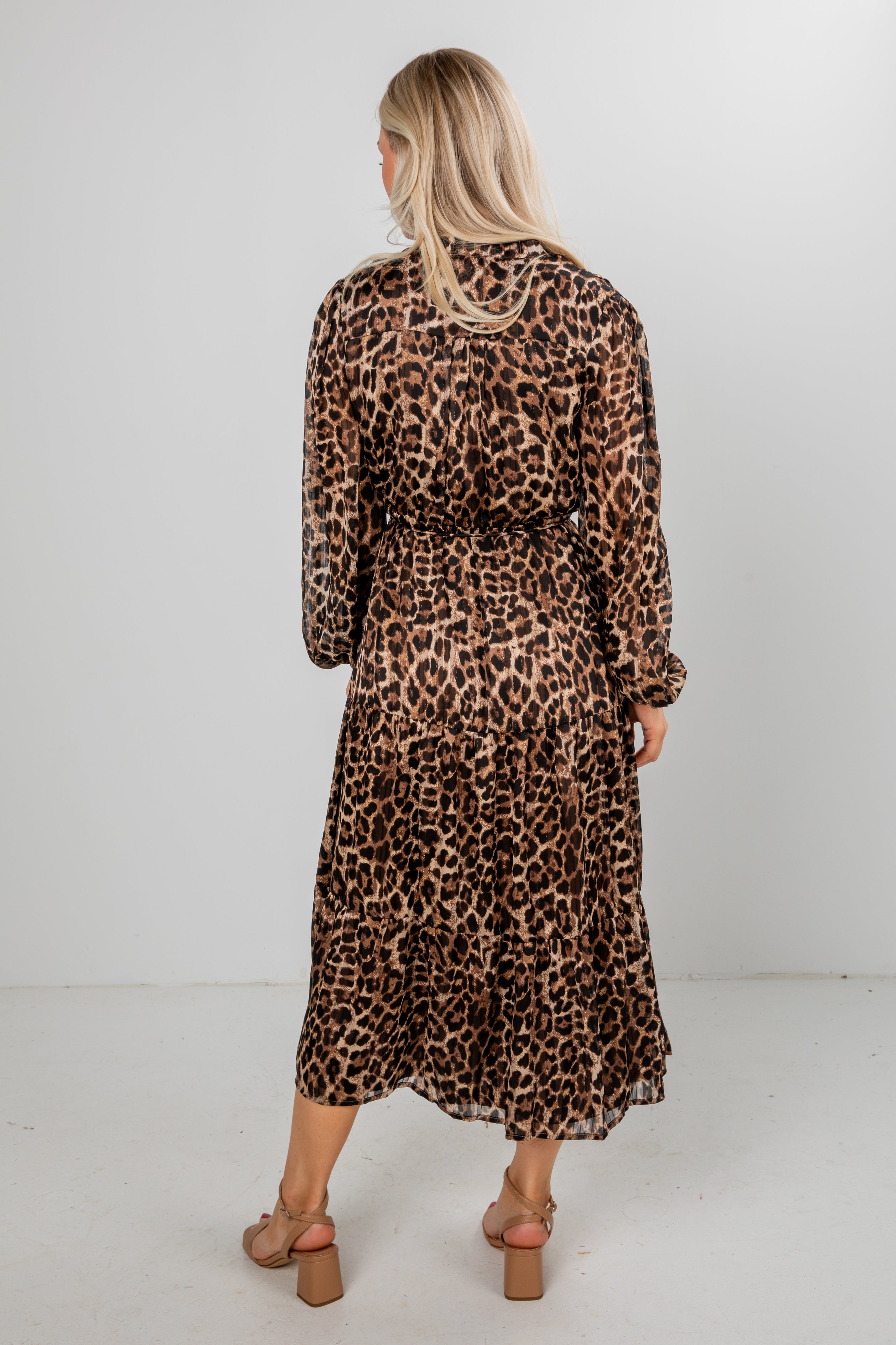 Woman wearing a leopard print dress on a white background
