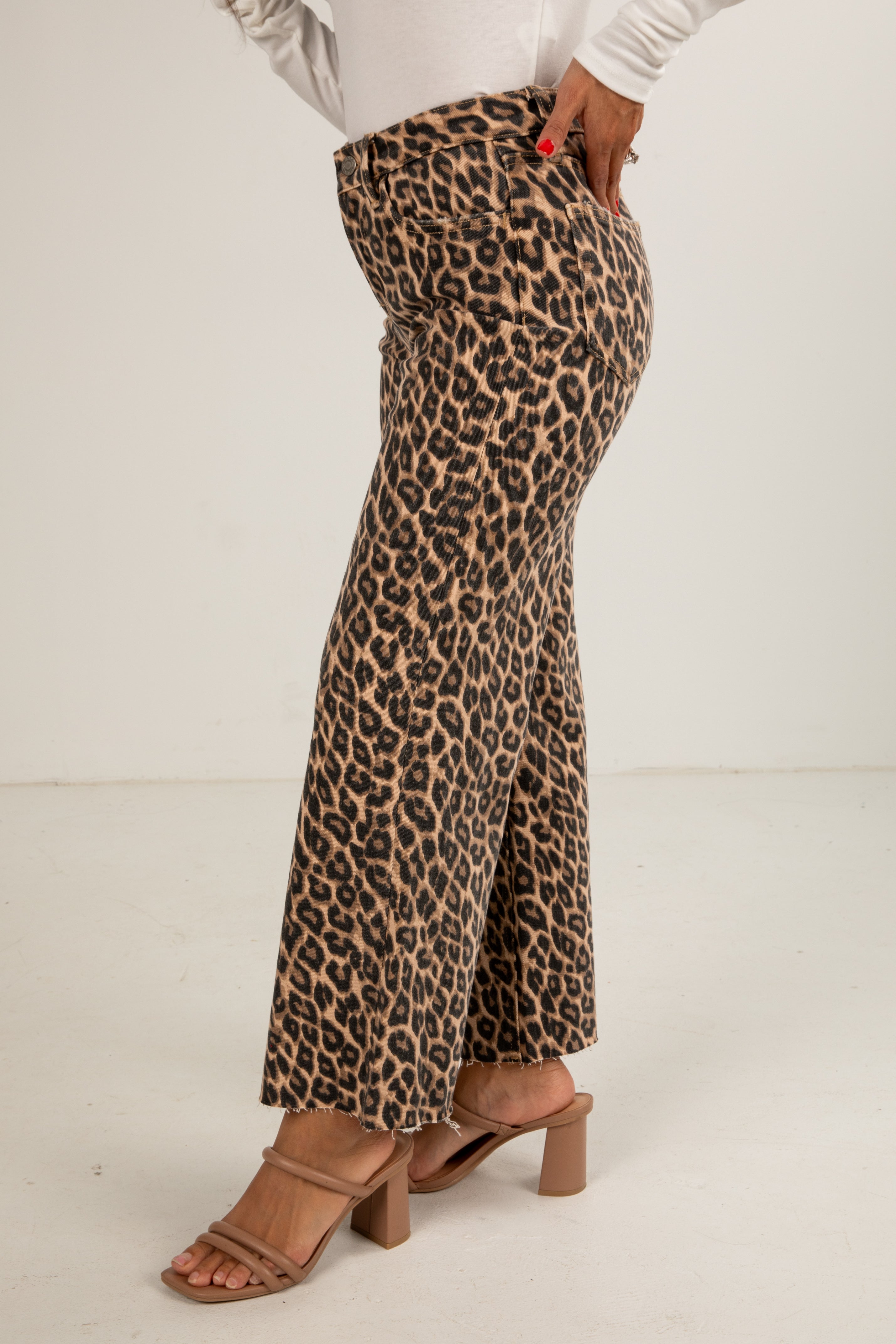 Person wearing leopard print pants on a white background