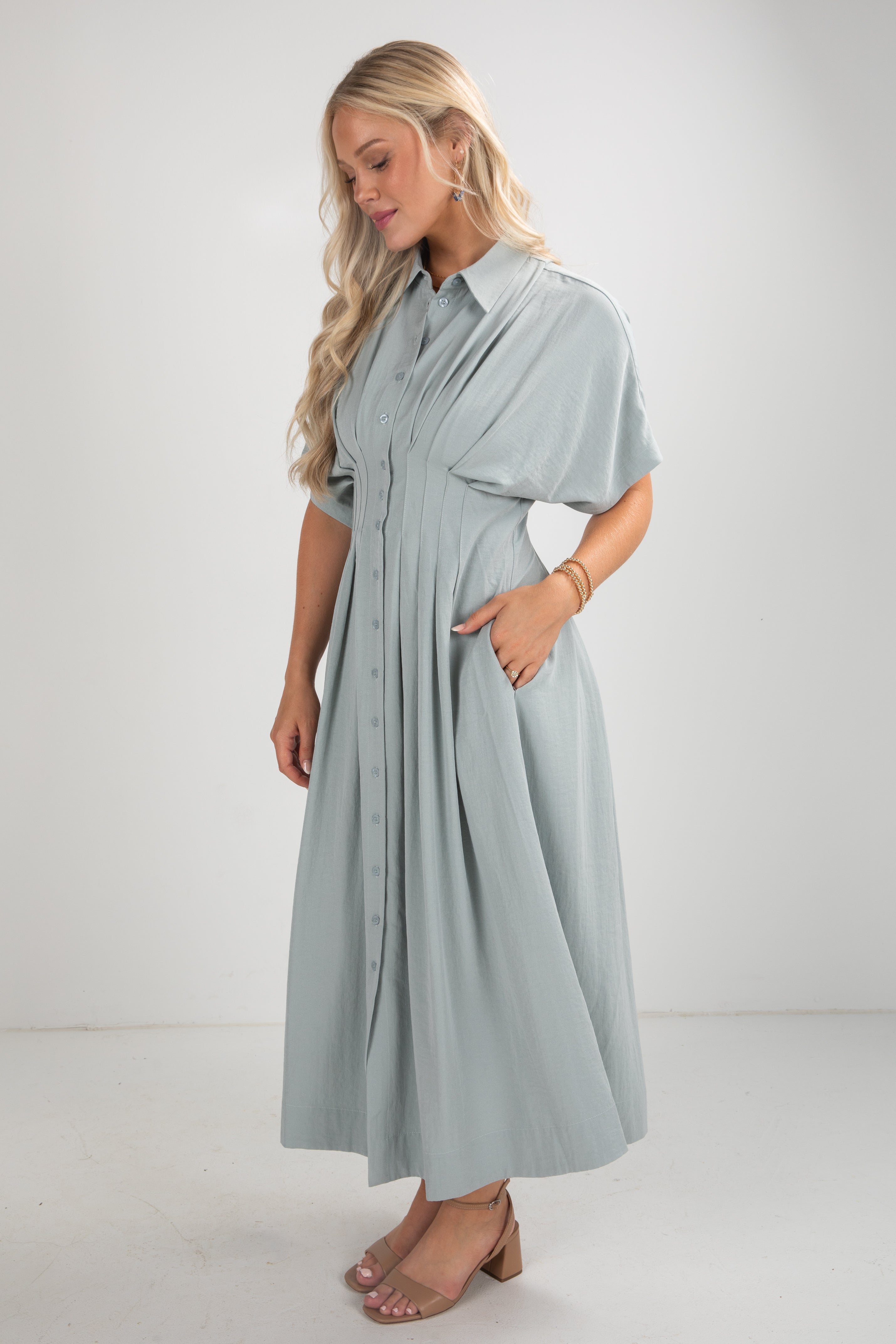 Woman wearing a light blue dress with a plain background