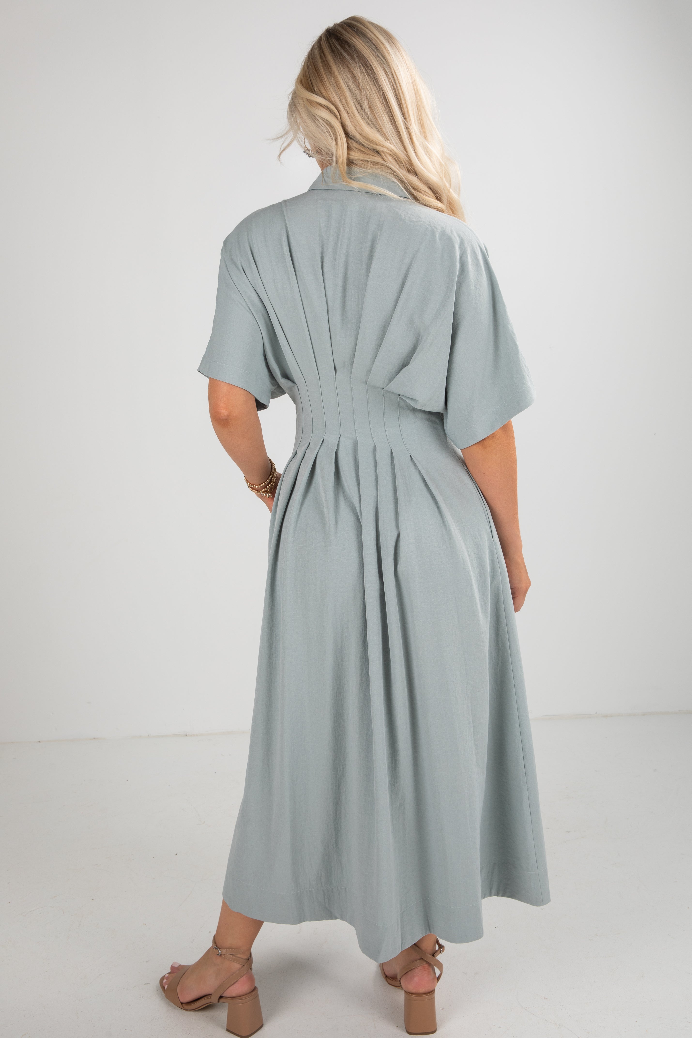 Woman wearing a light blue dress against a white background