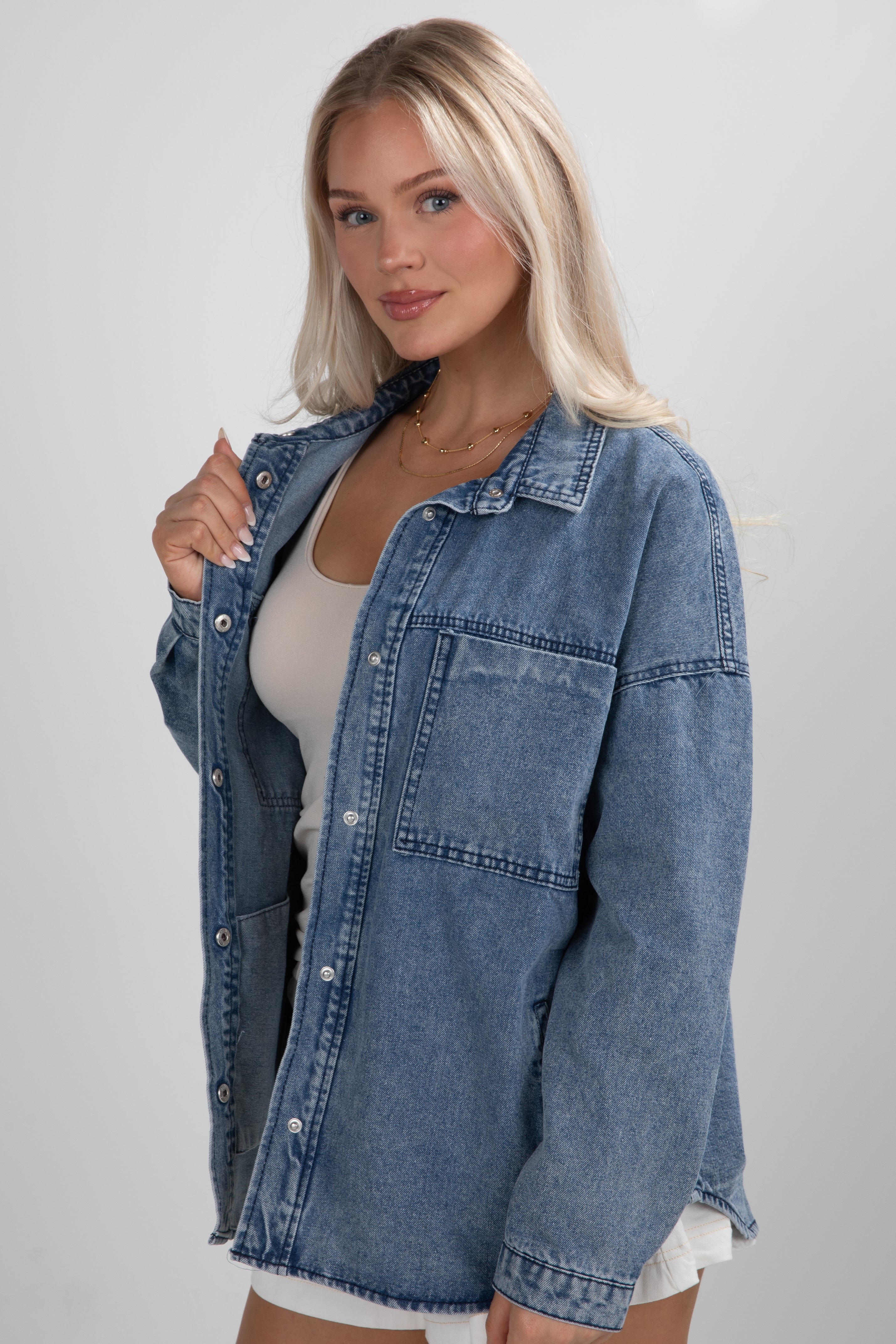 Woman wearing a denim jacket on a plain background