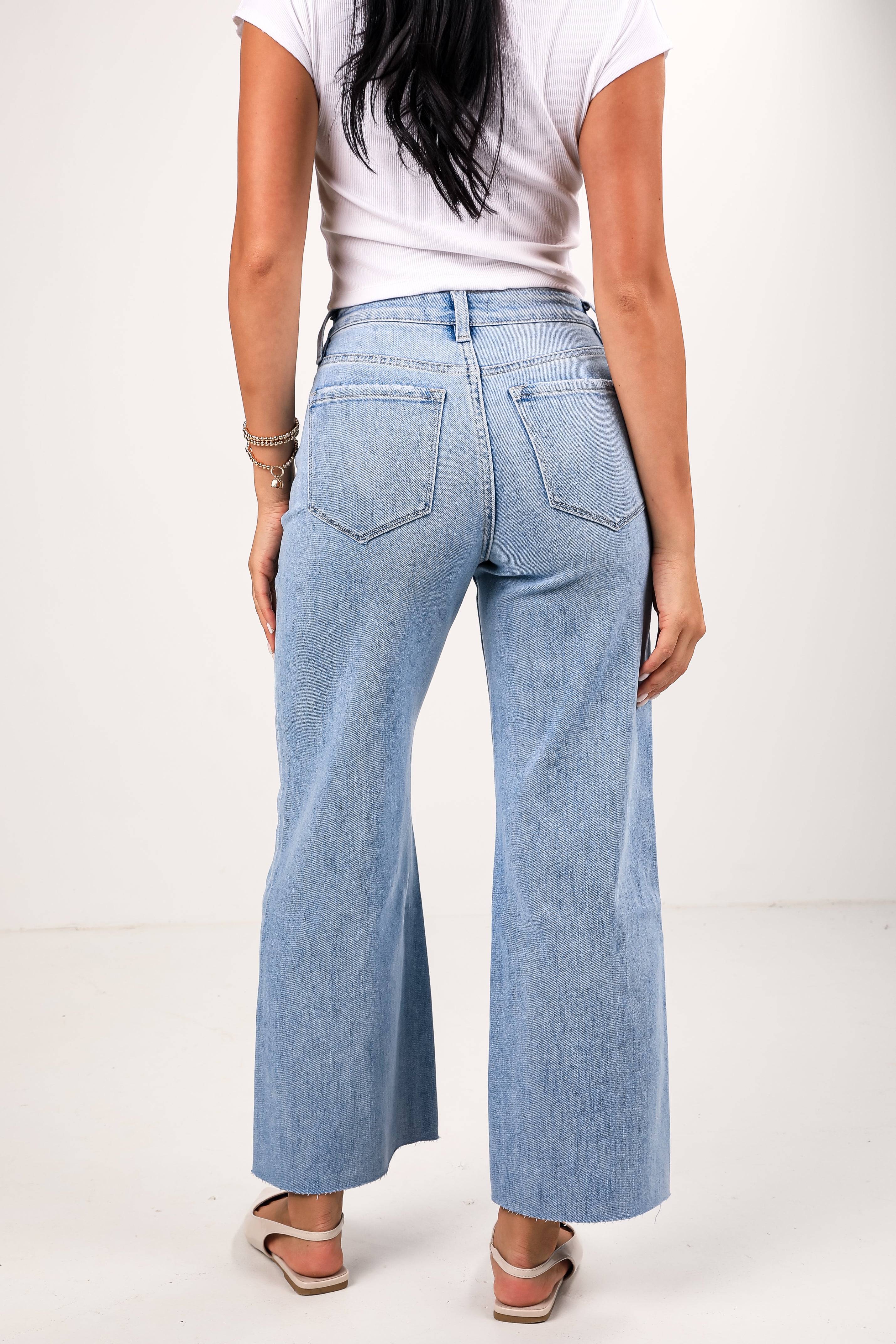 Light blue flared jeans worn by a person on a white background