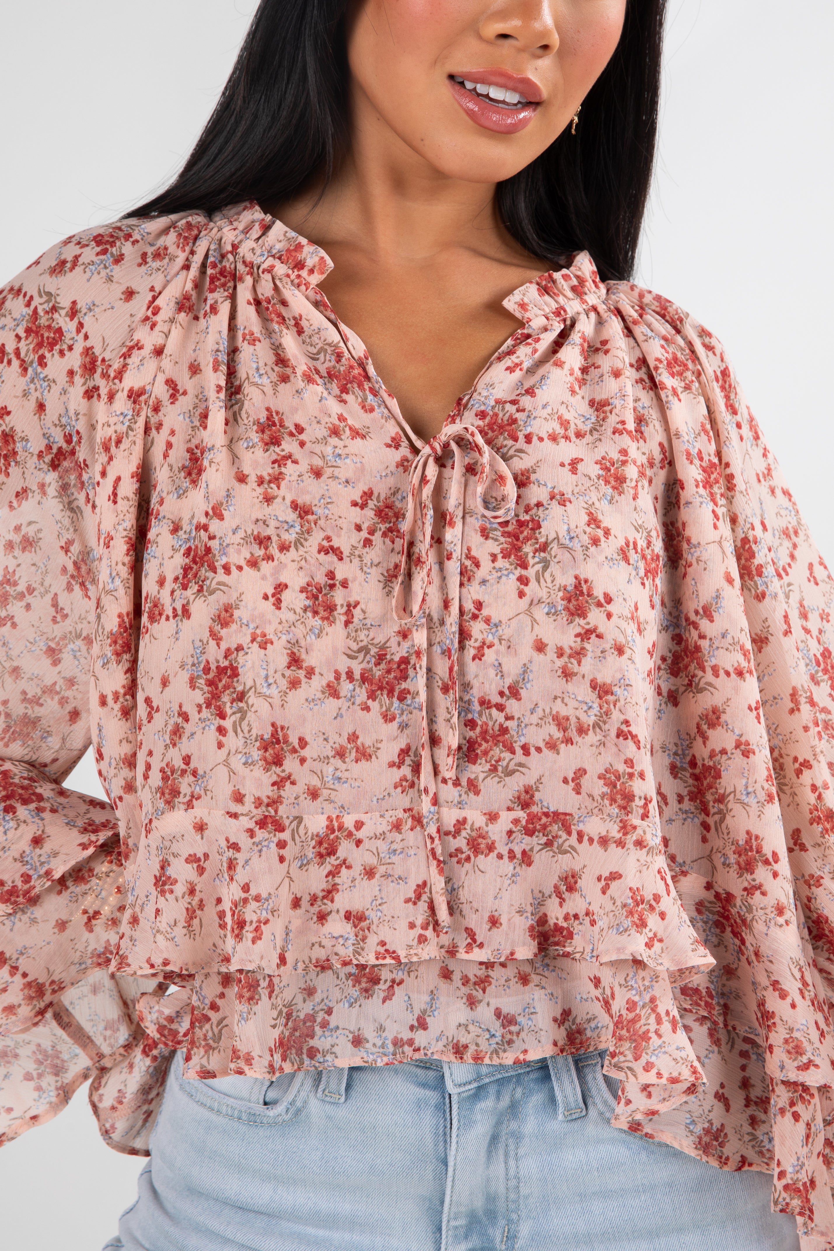 Woman wearing a floral blouse with a plain background