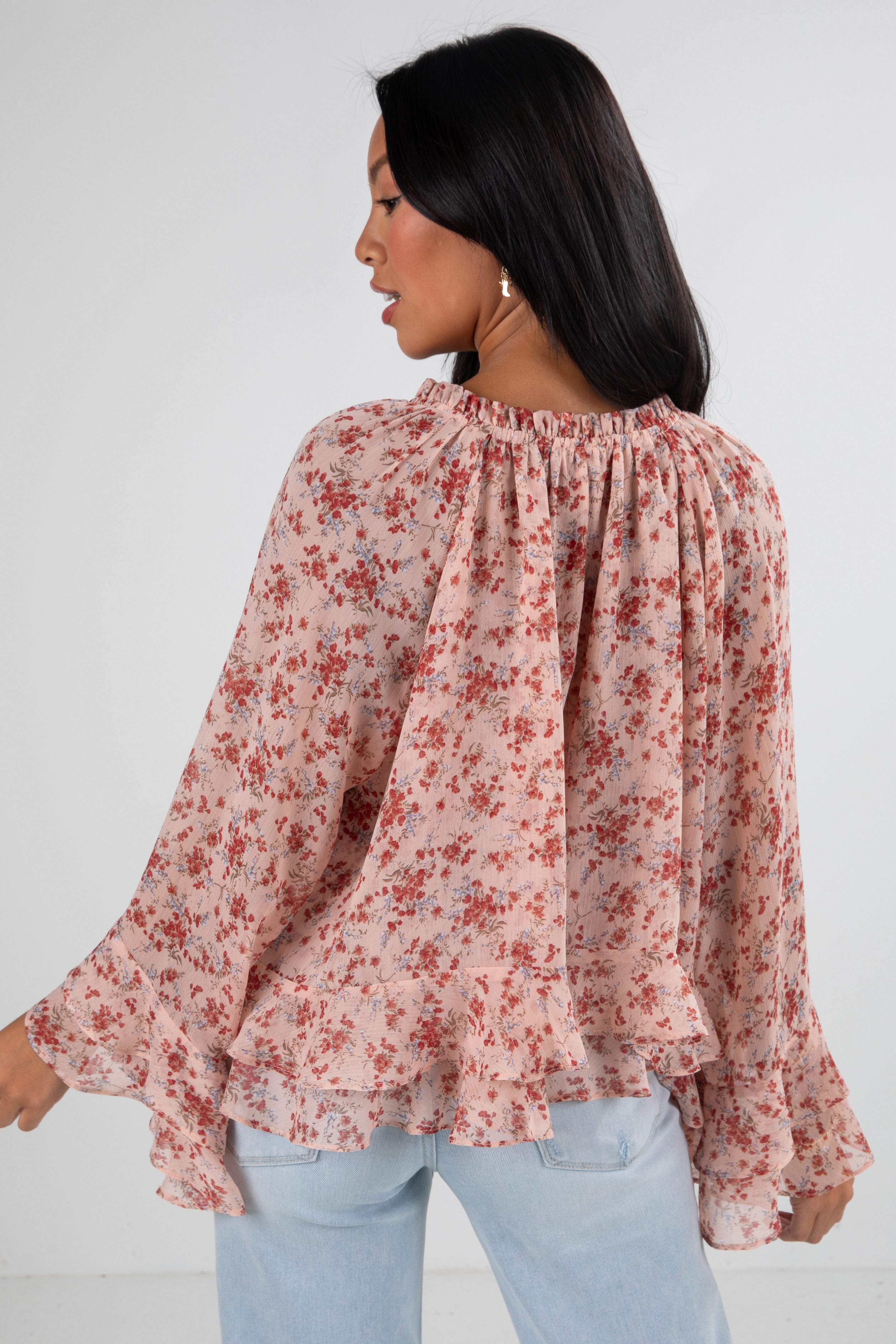 Woman wearing a floral blouse with long sleeves on a white background