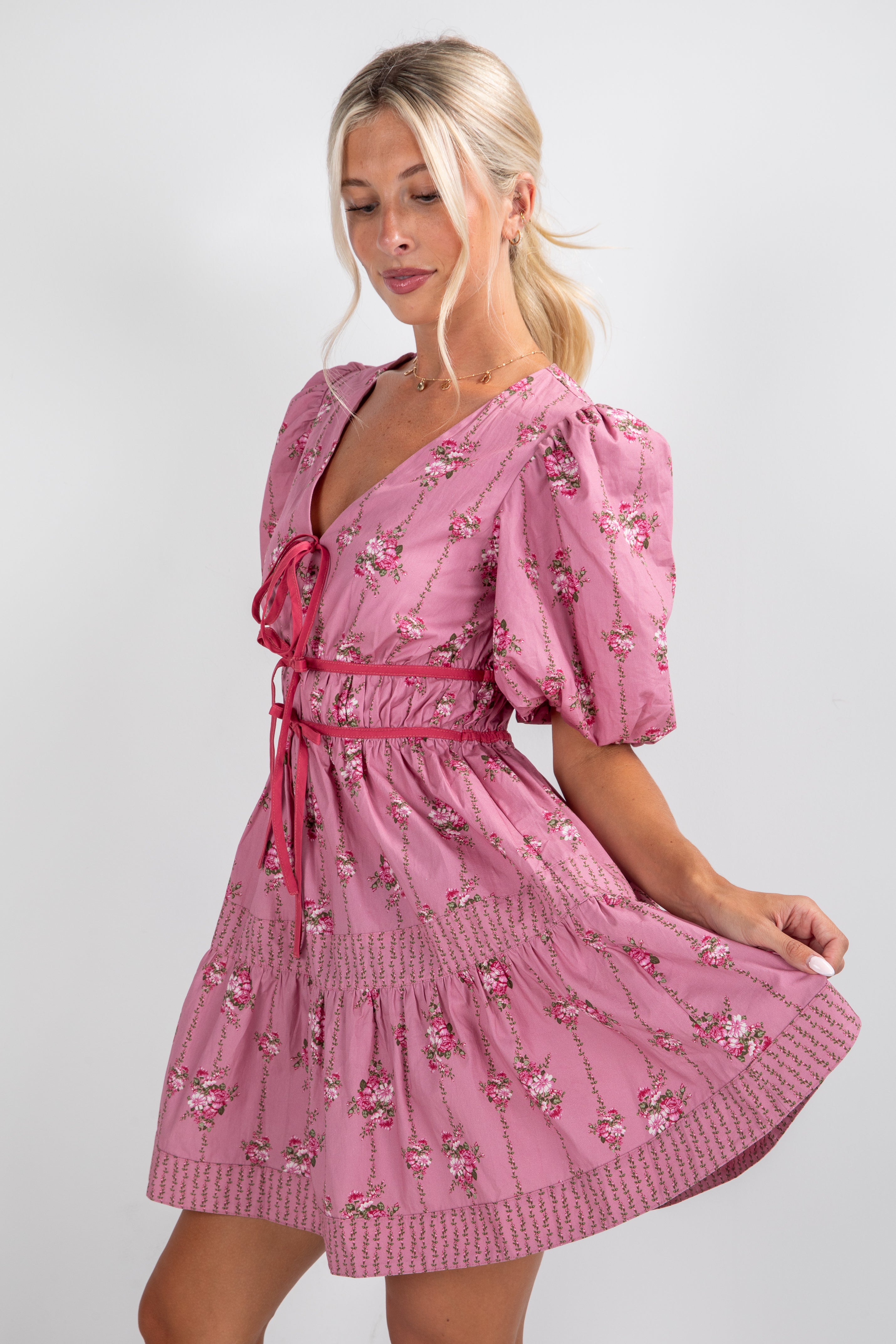 Woman wearing a pink floral dress on a white background