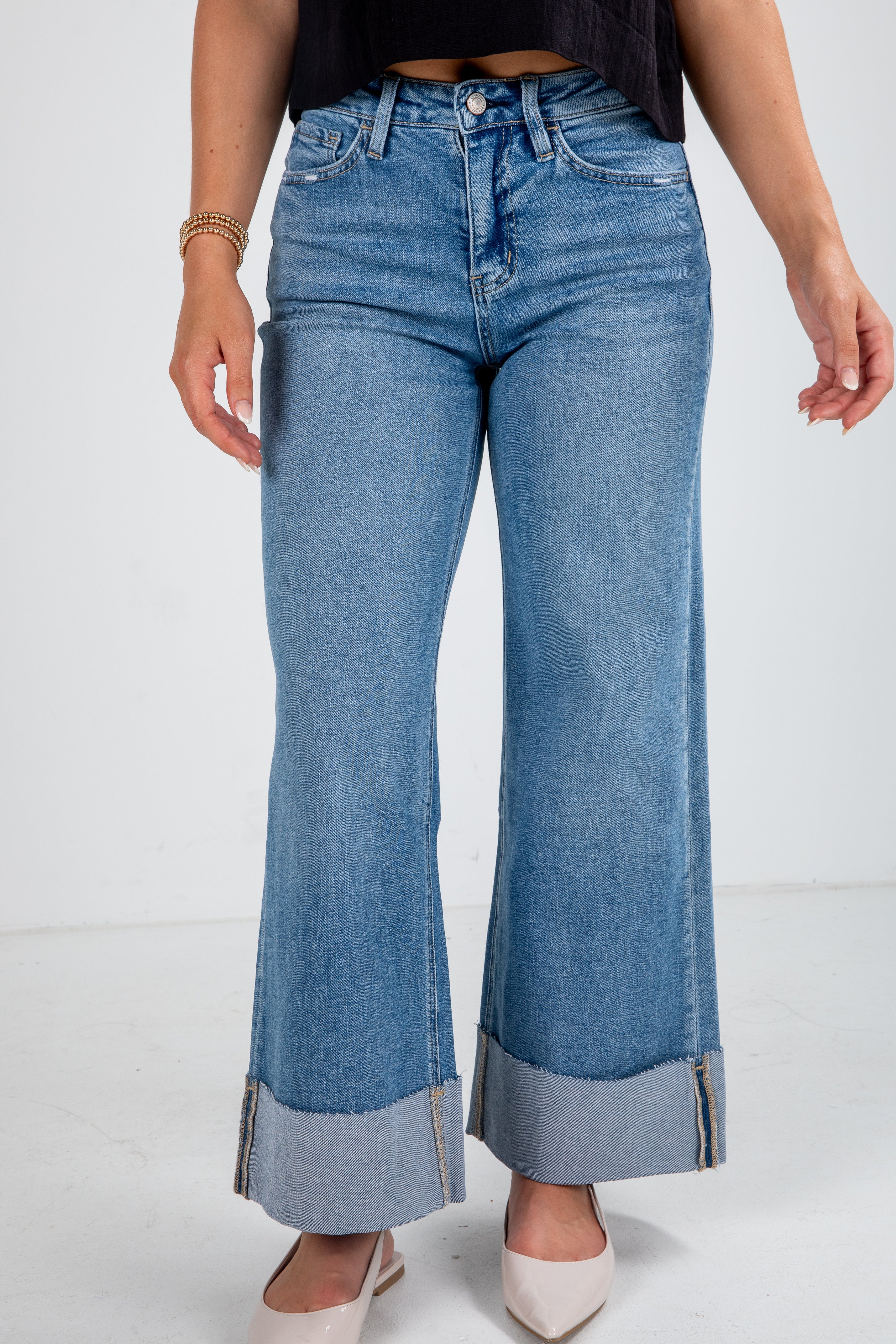 Person wearing blue flared jeans on a white background