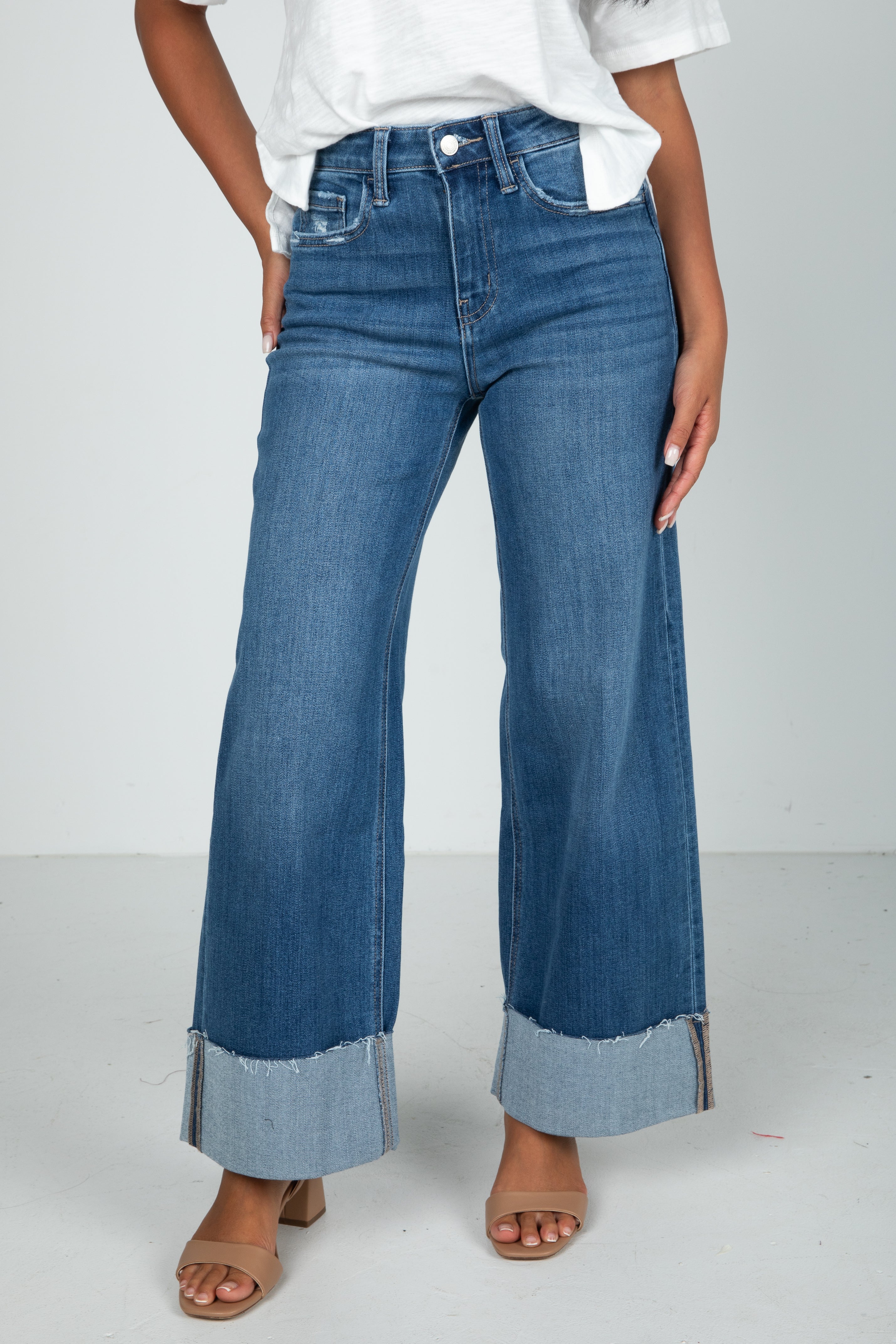 Person wearing blue wide-leg jeans on a white background