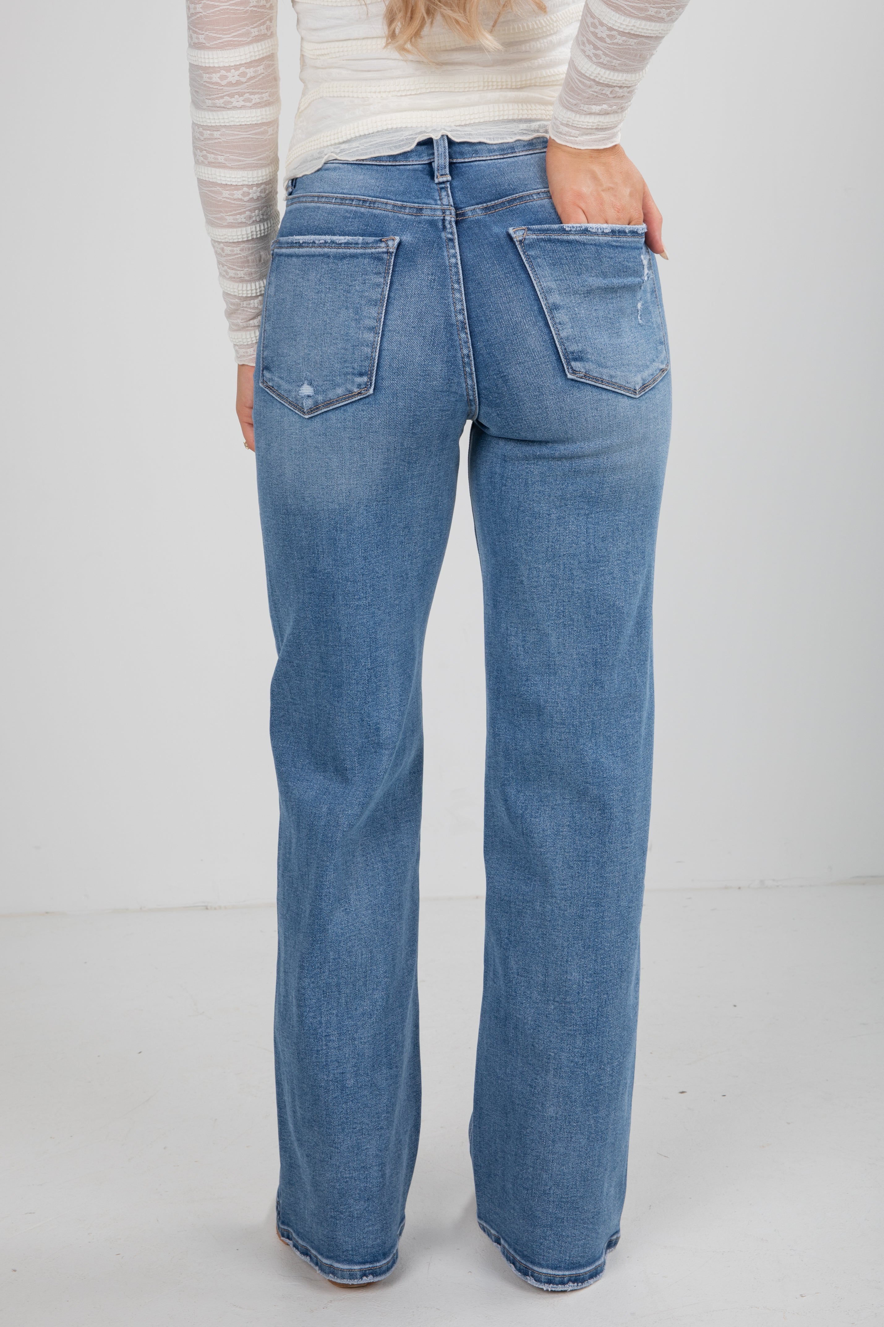 Person wearing blue jeans on a white background