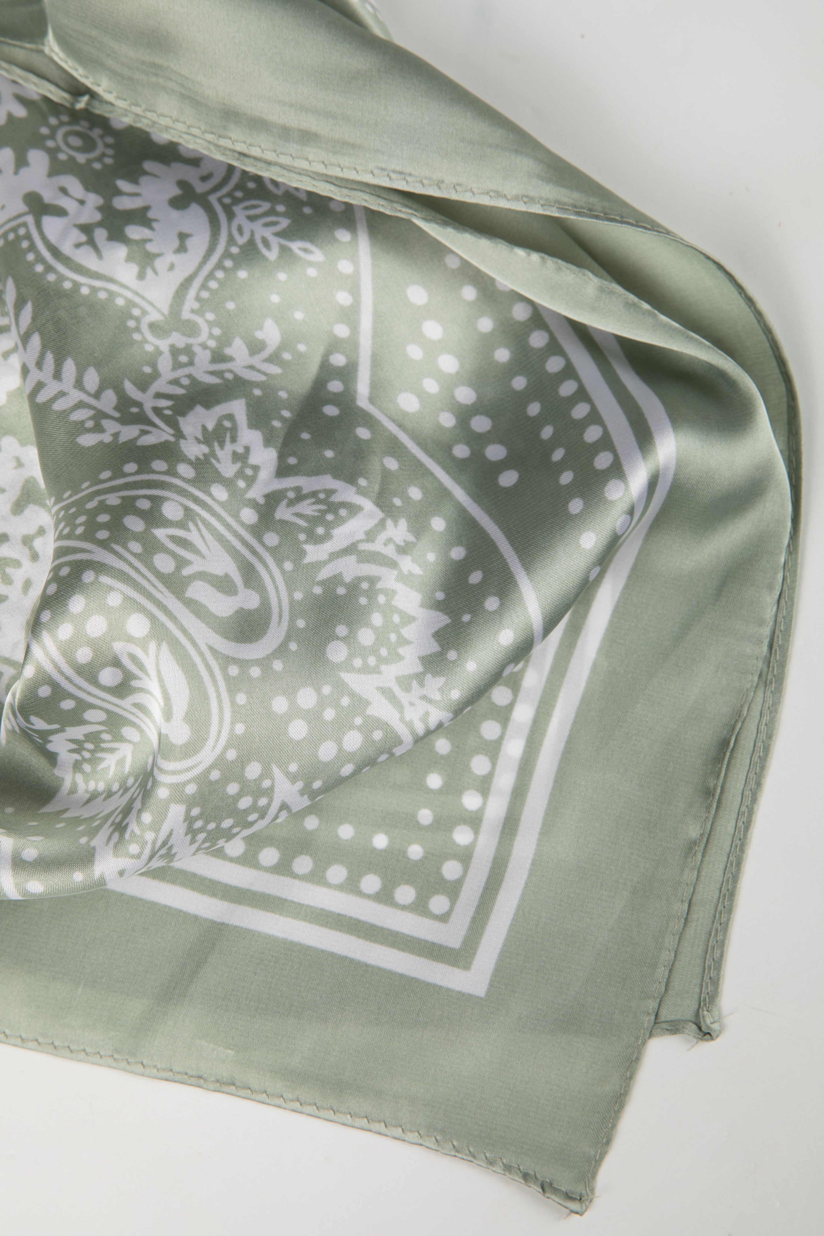 Green bandana with white paisley pattern on a white background