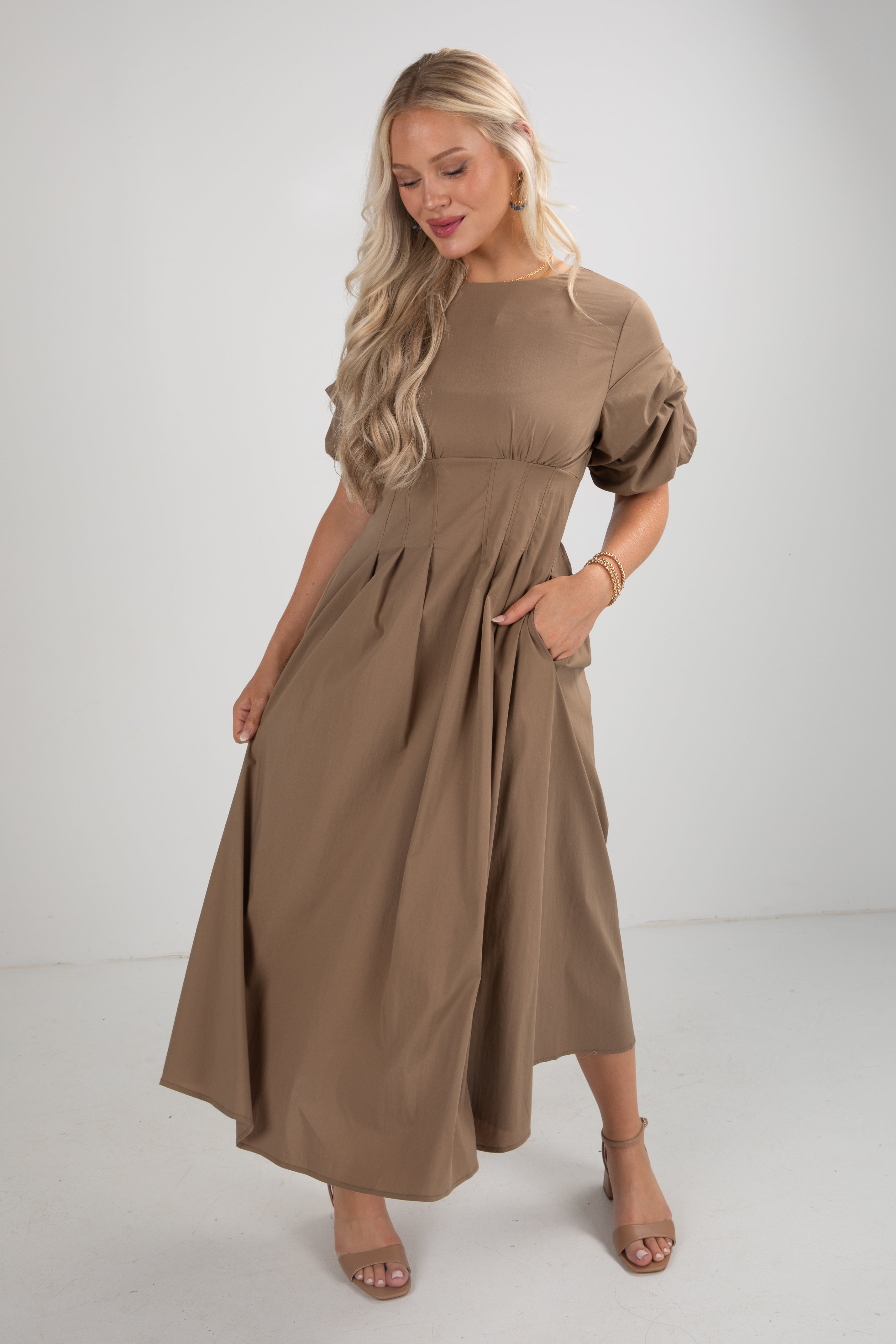 Woman wearing a brown dress on a white background