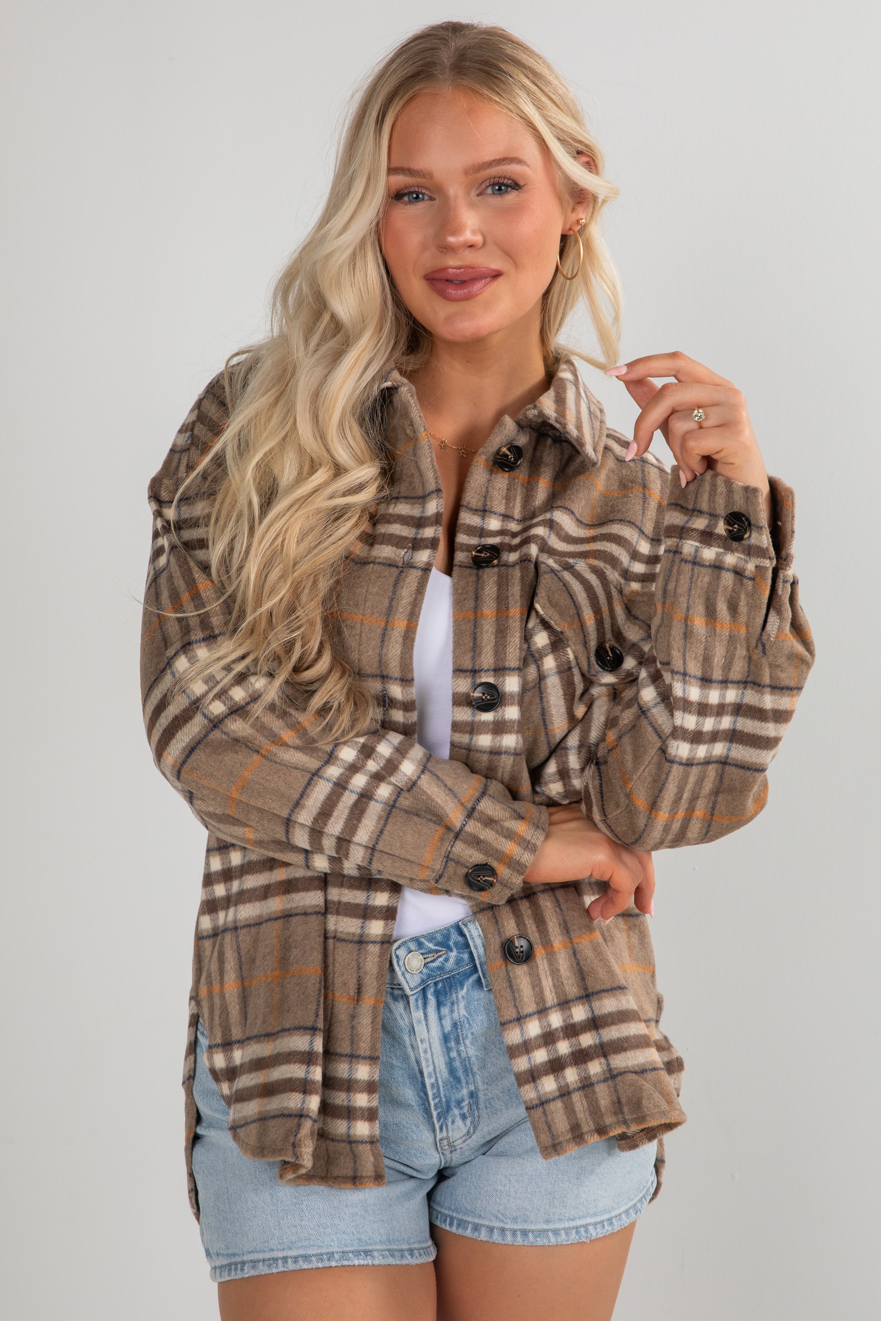 Woman wearing a plaid jacket with a plain background