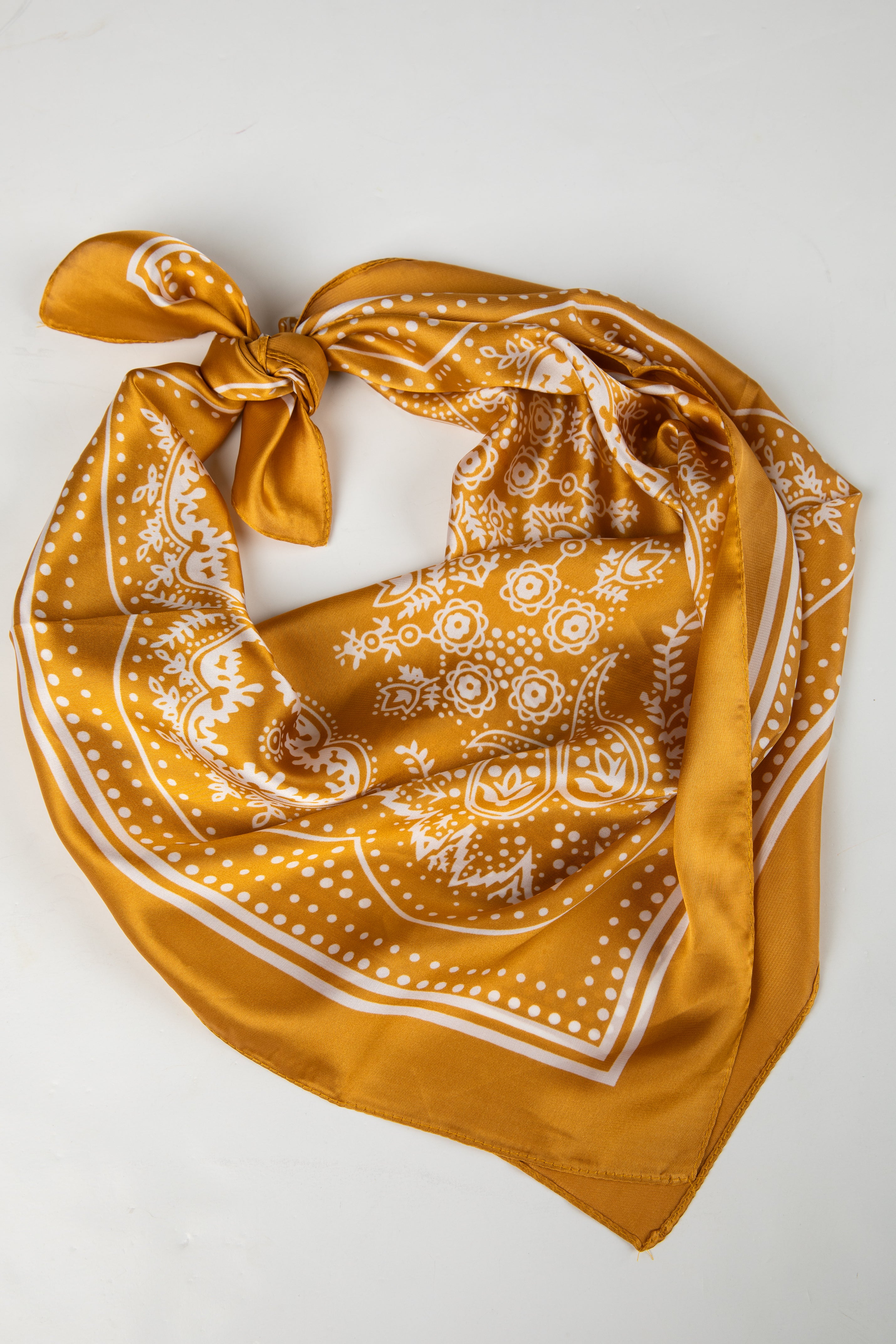 Yellow bandana with white patterns on a light gray background