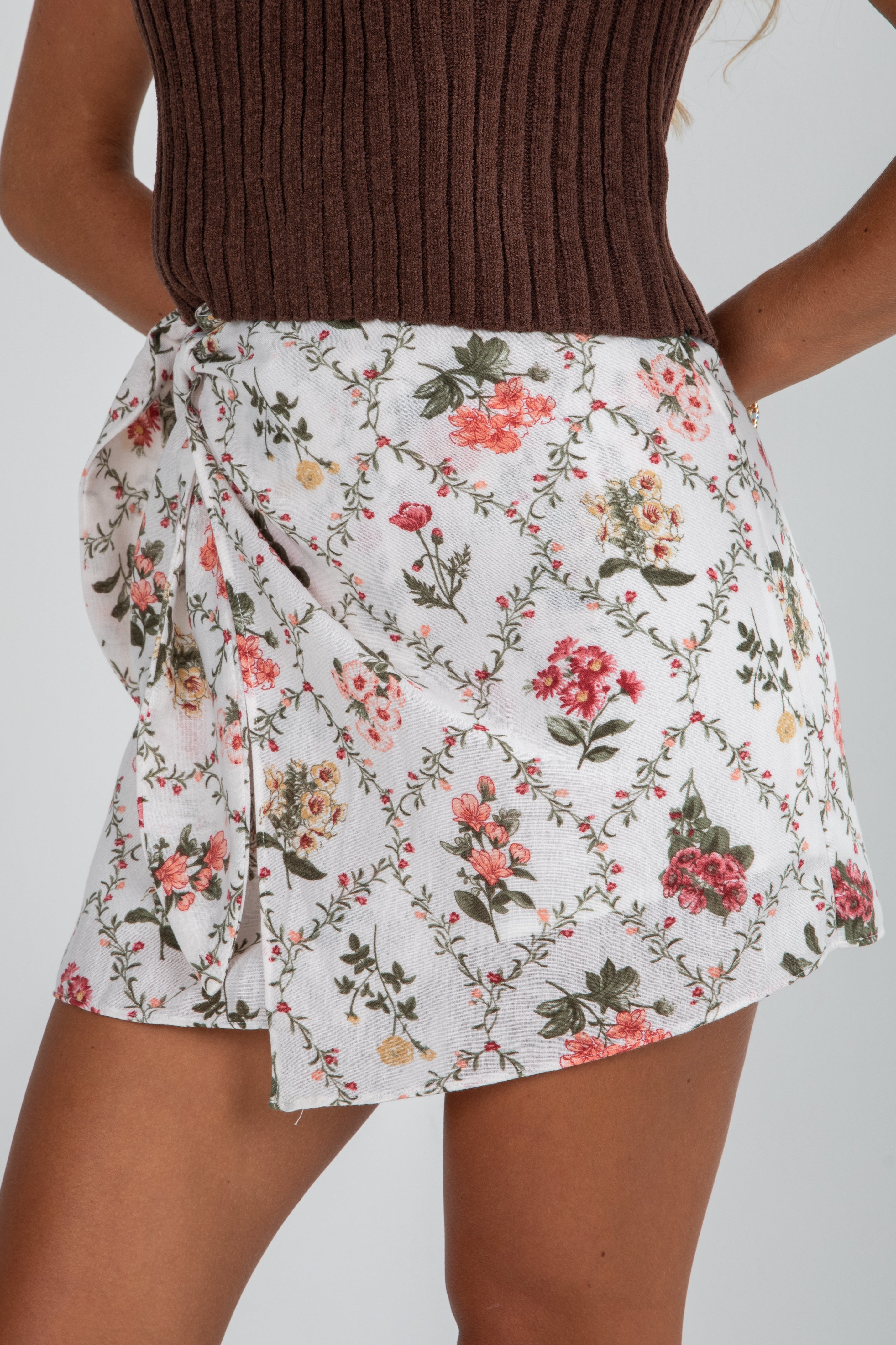 Floral skirt worn by a person on a plain background