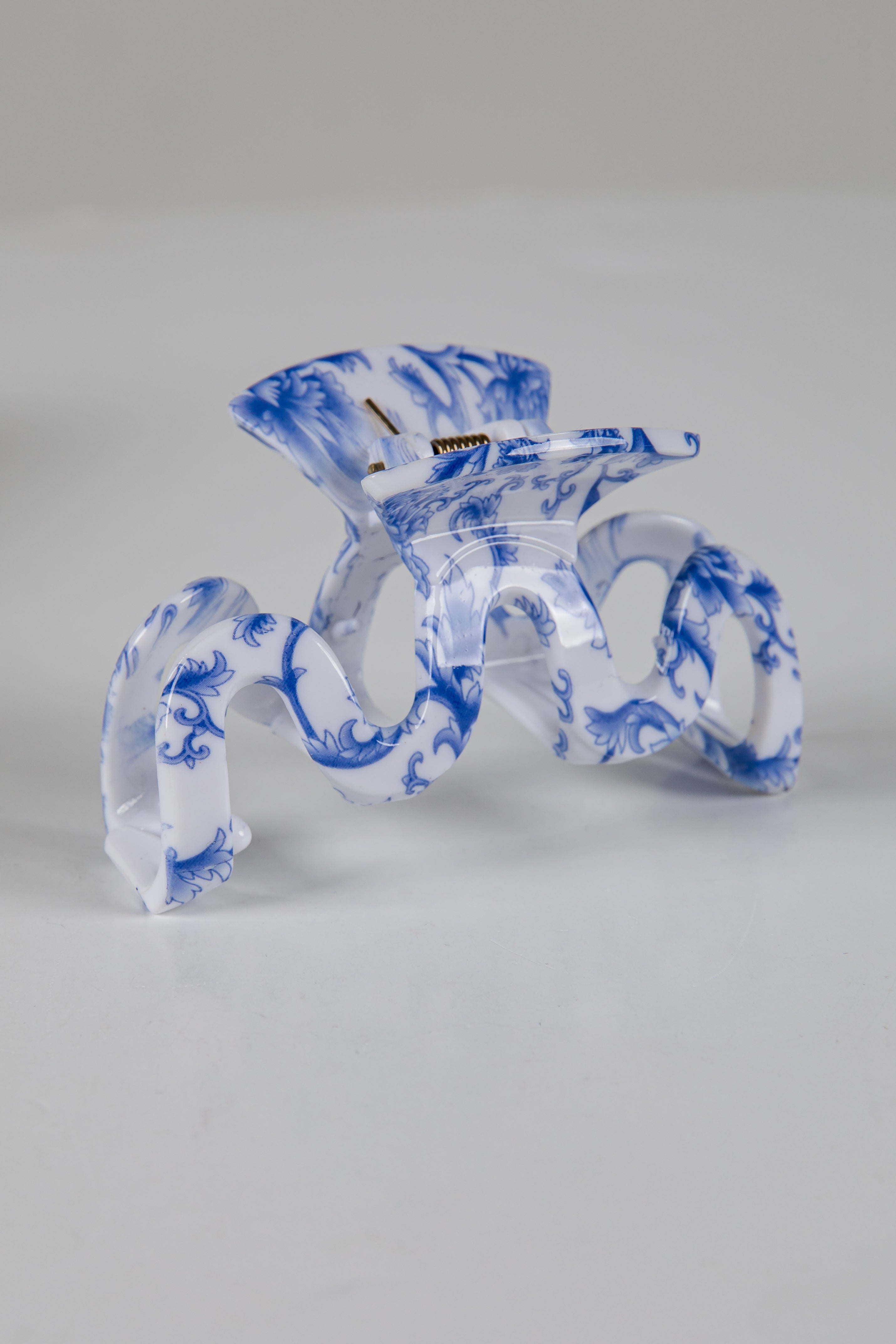 Decorative glass piece with blue and white patterns on a gray background