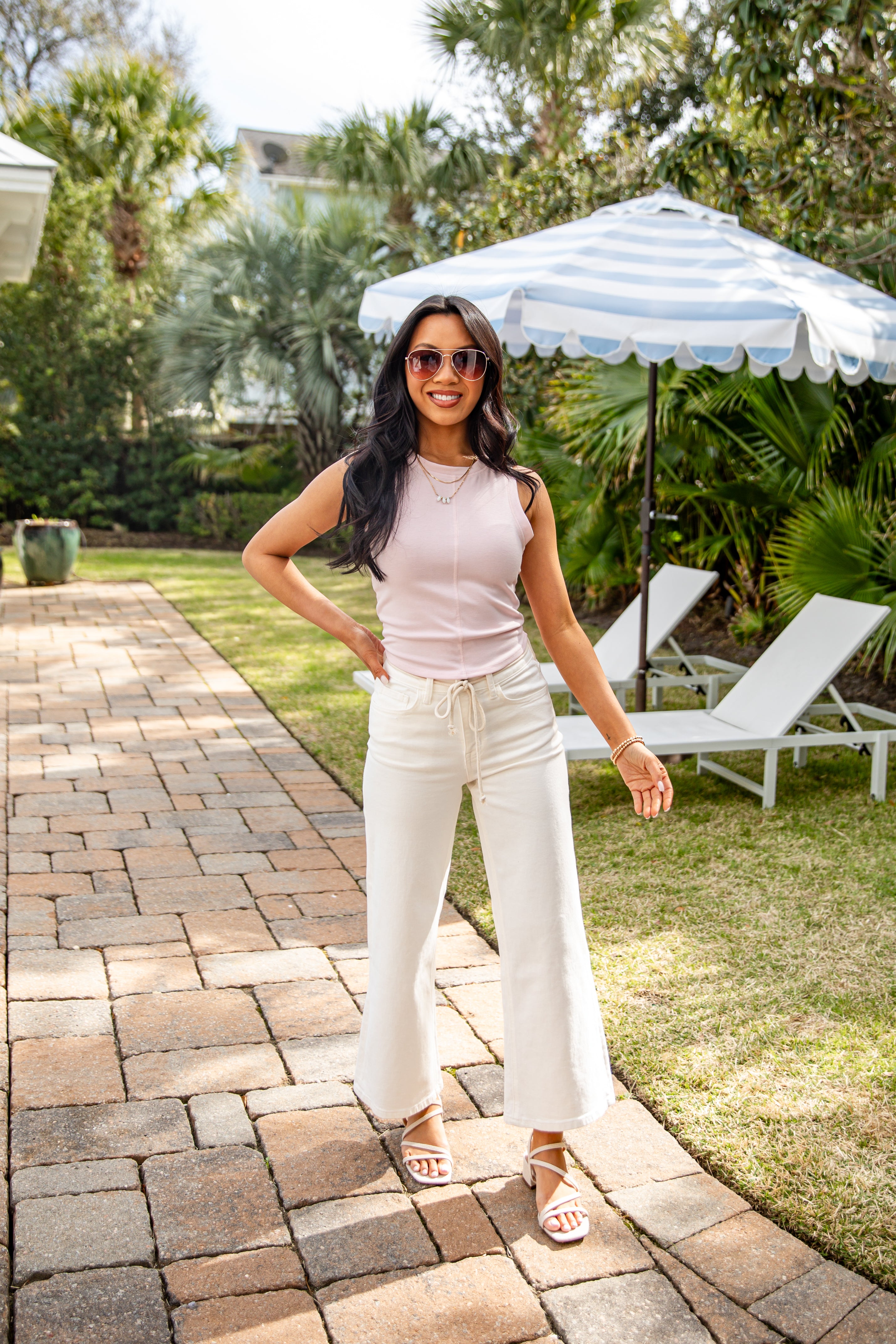 Woman standing on a patio with a garden background