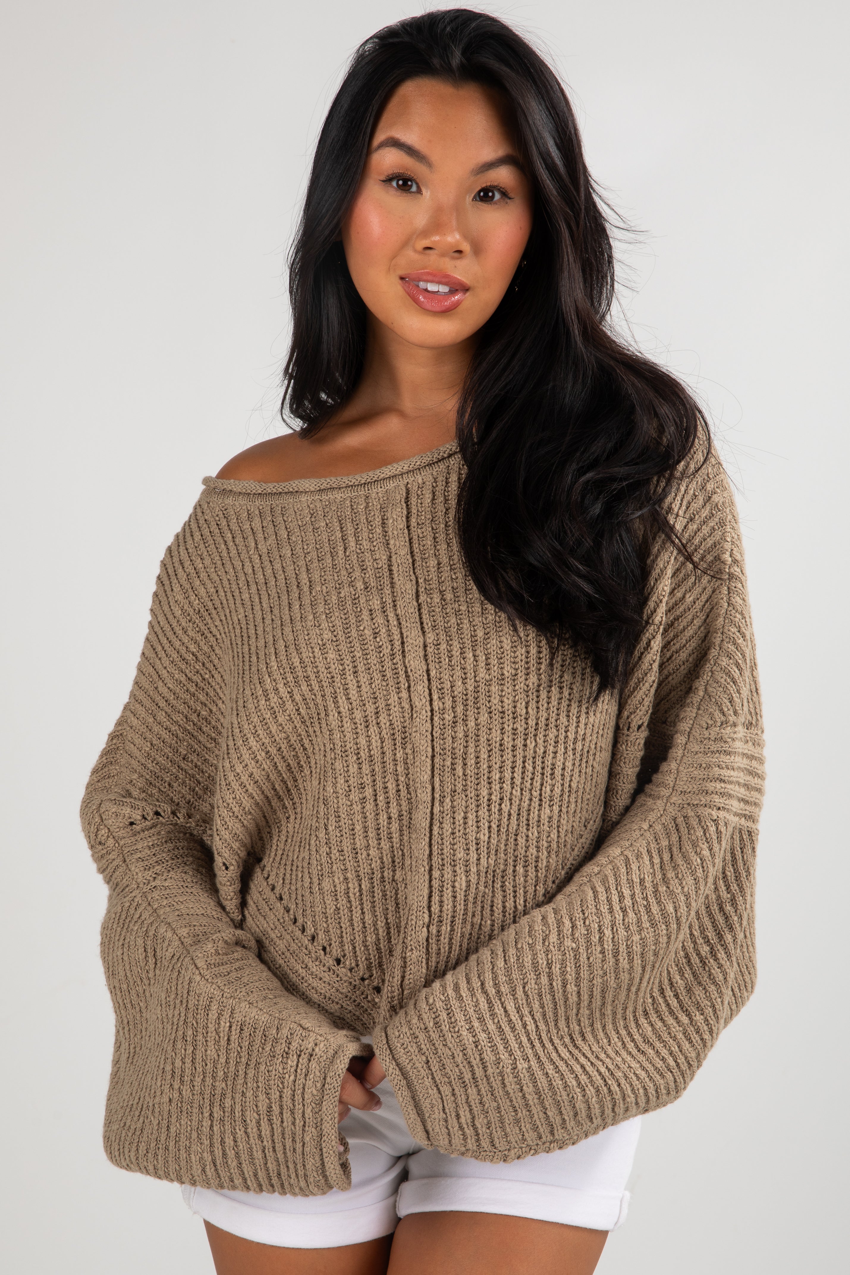Woman wearing a beige sweater against a white background