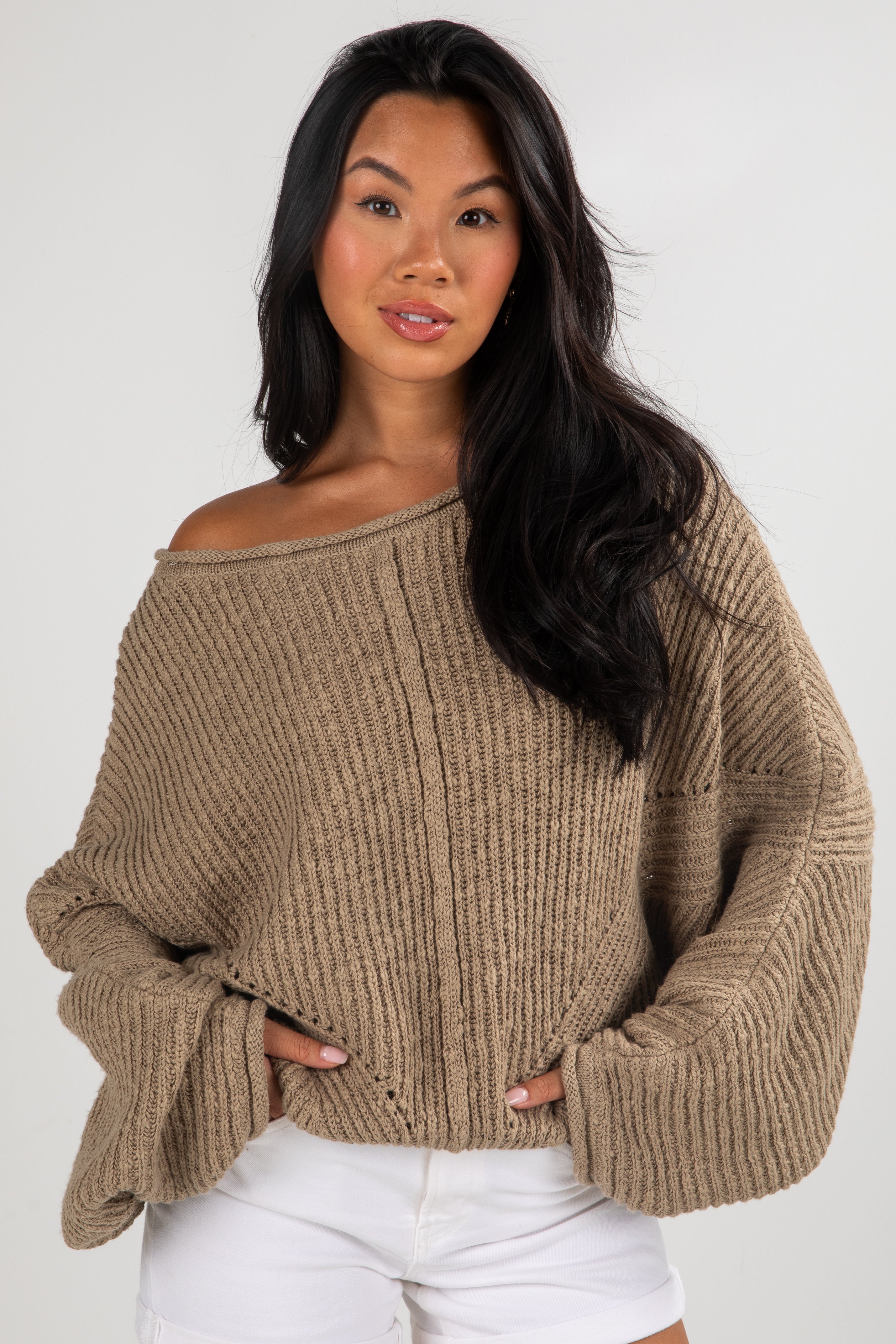Woman wearing a beige sweater against a white background