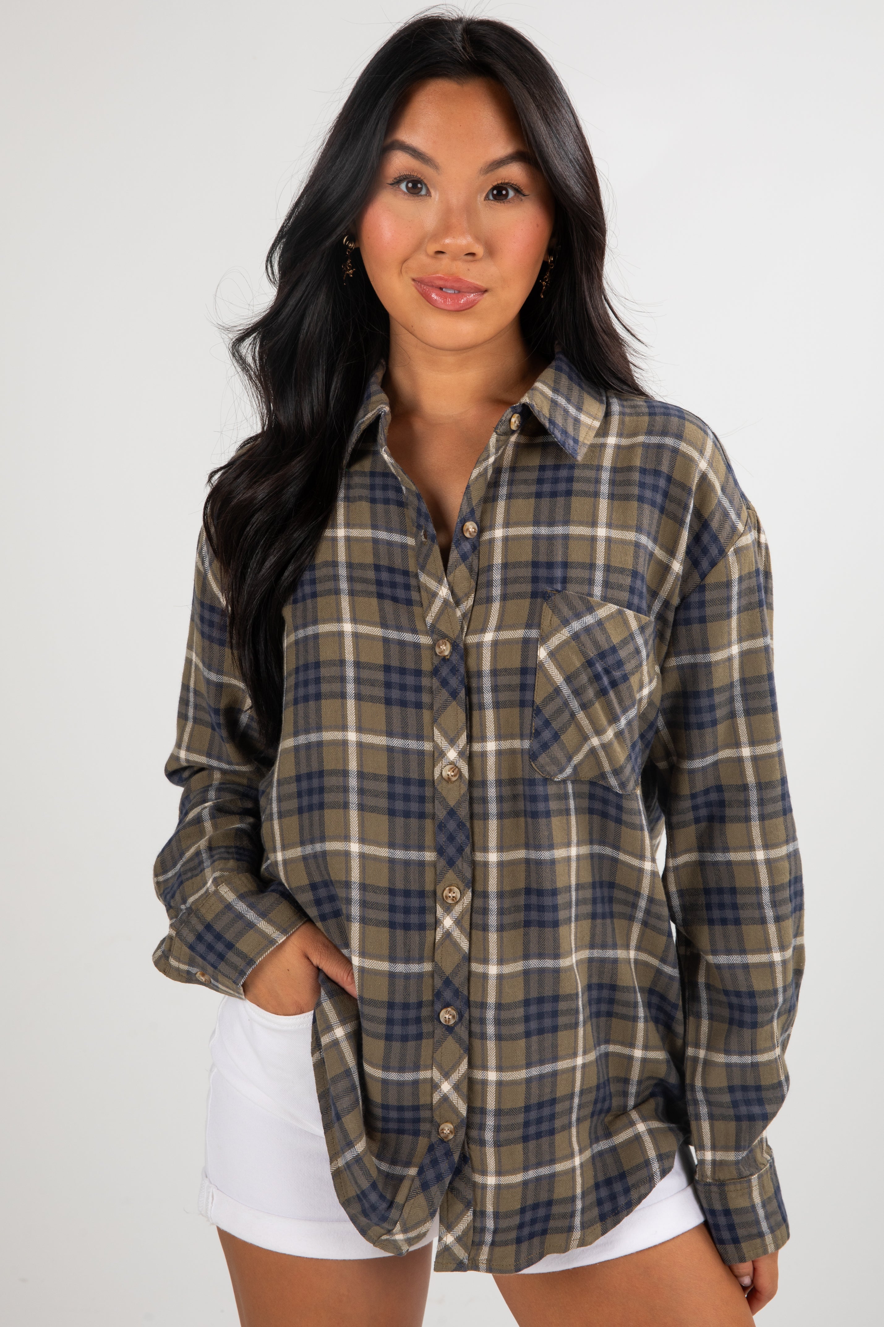 Woman wearing a plaid shirt with a plain background