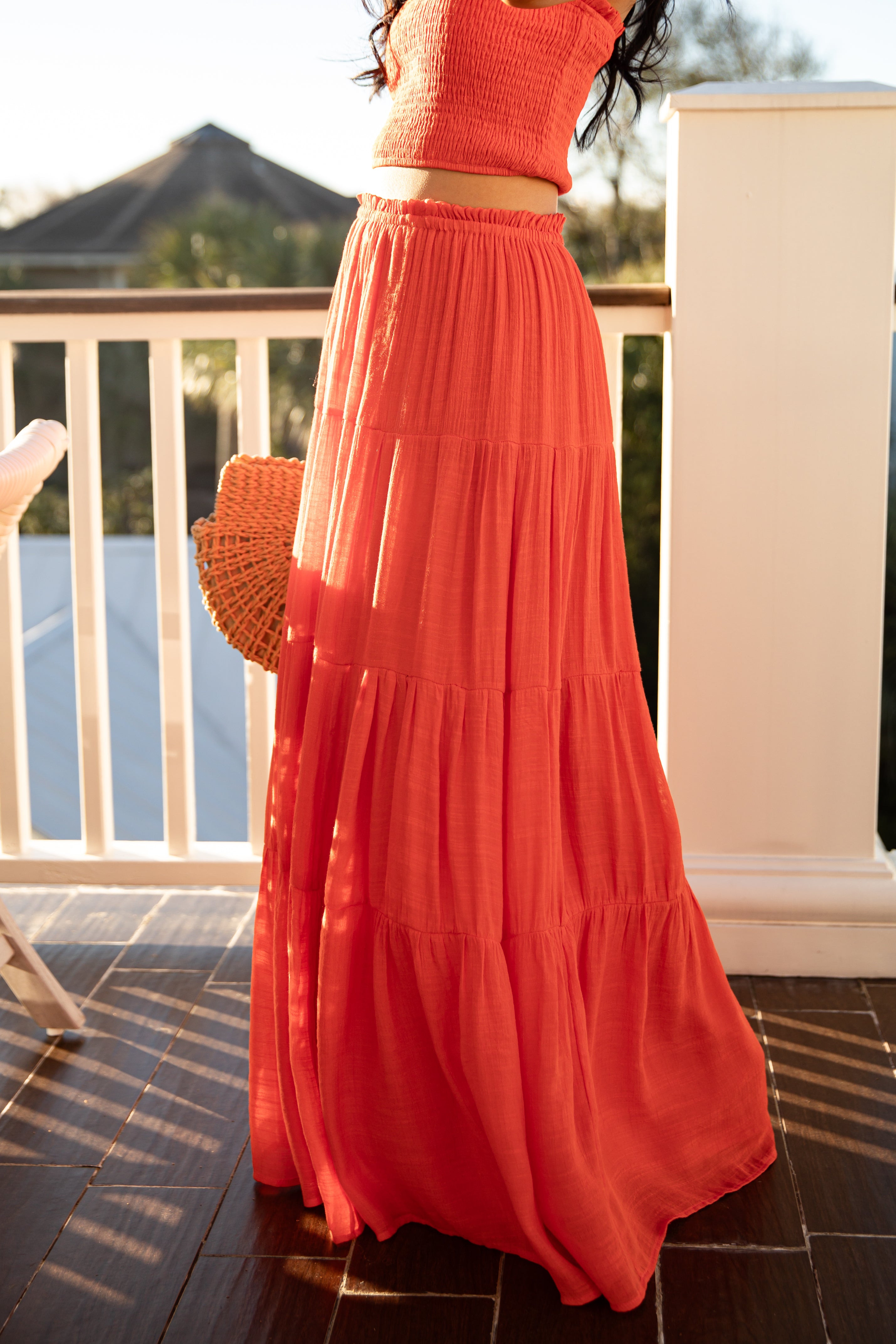 Person wearing an orange outfit on a balcony