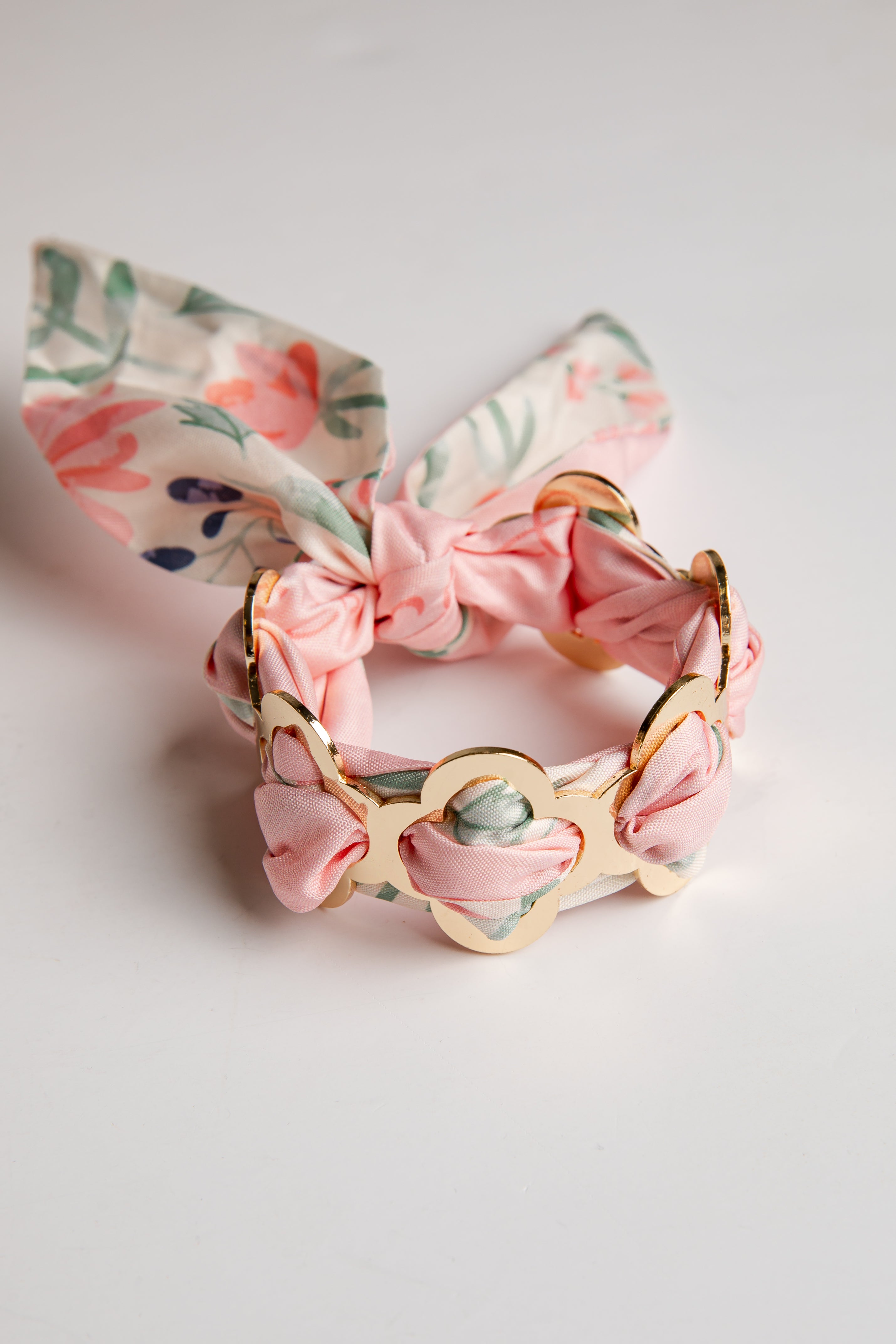 Floral bracelet with pink bow on a light gray background