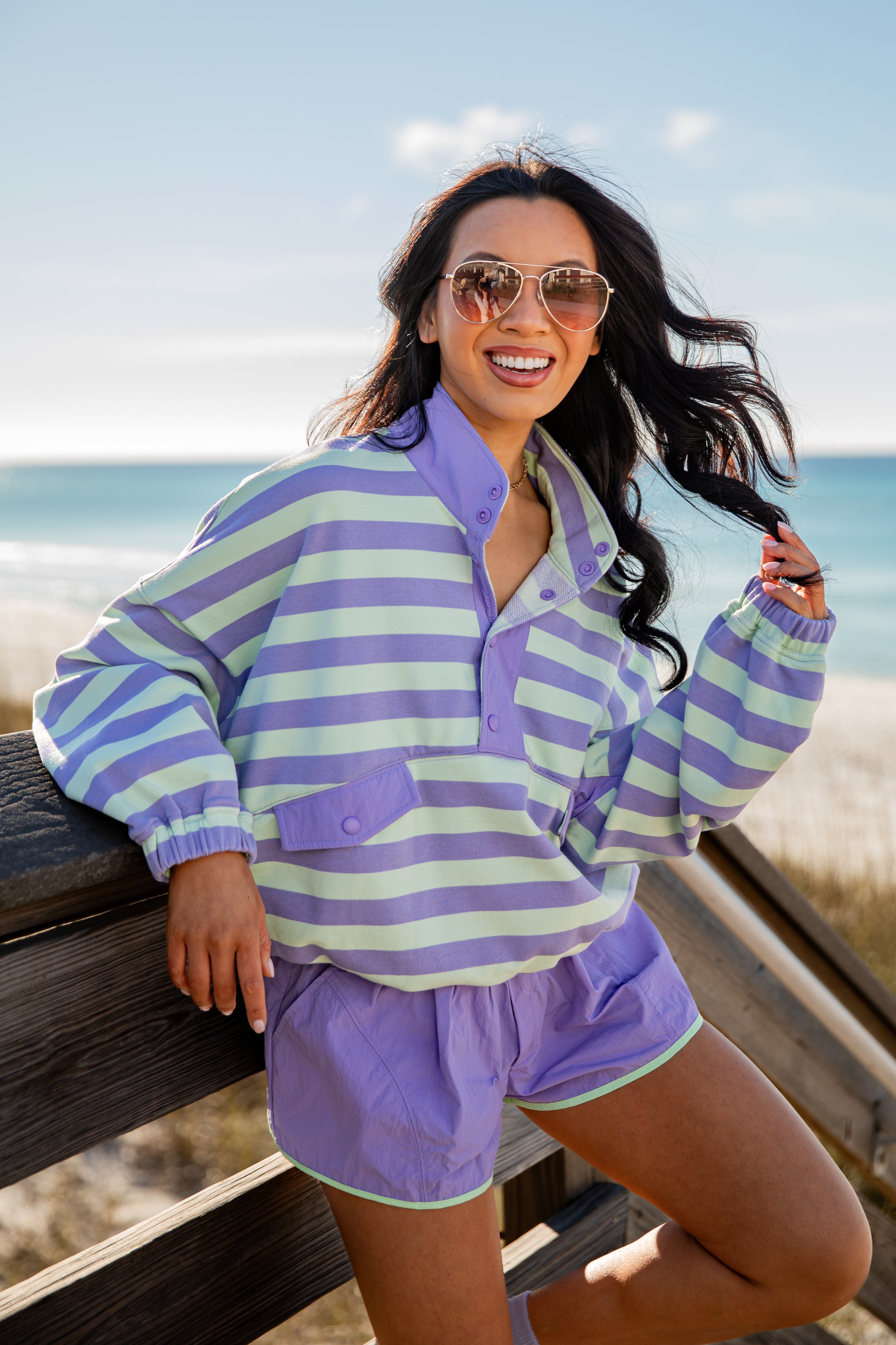 Woman wearing a striped shirt and shorts by the beach